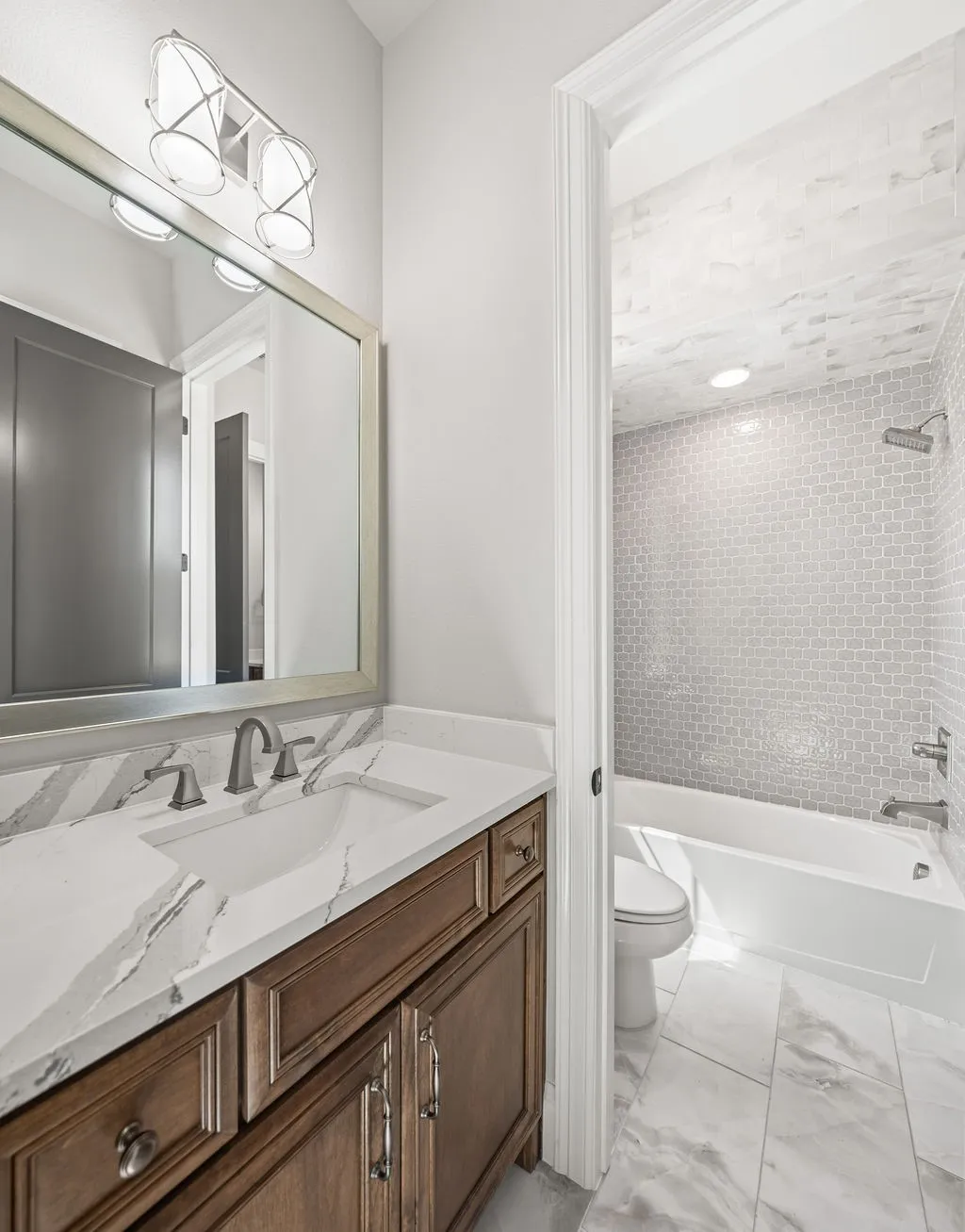White rectangular undermount sink with a brushed nickel faucet, set in a white countertop with gray veining