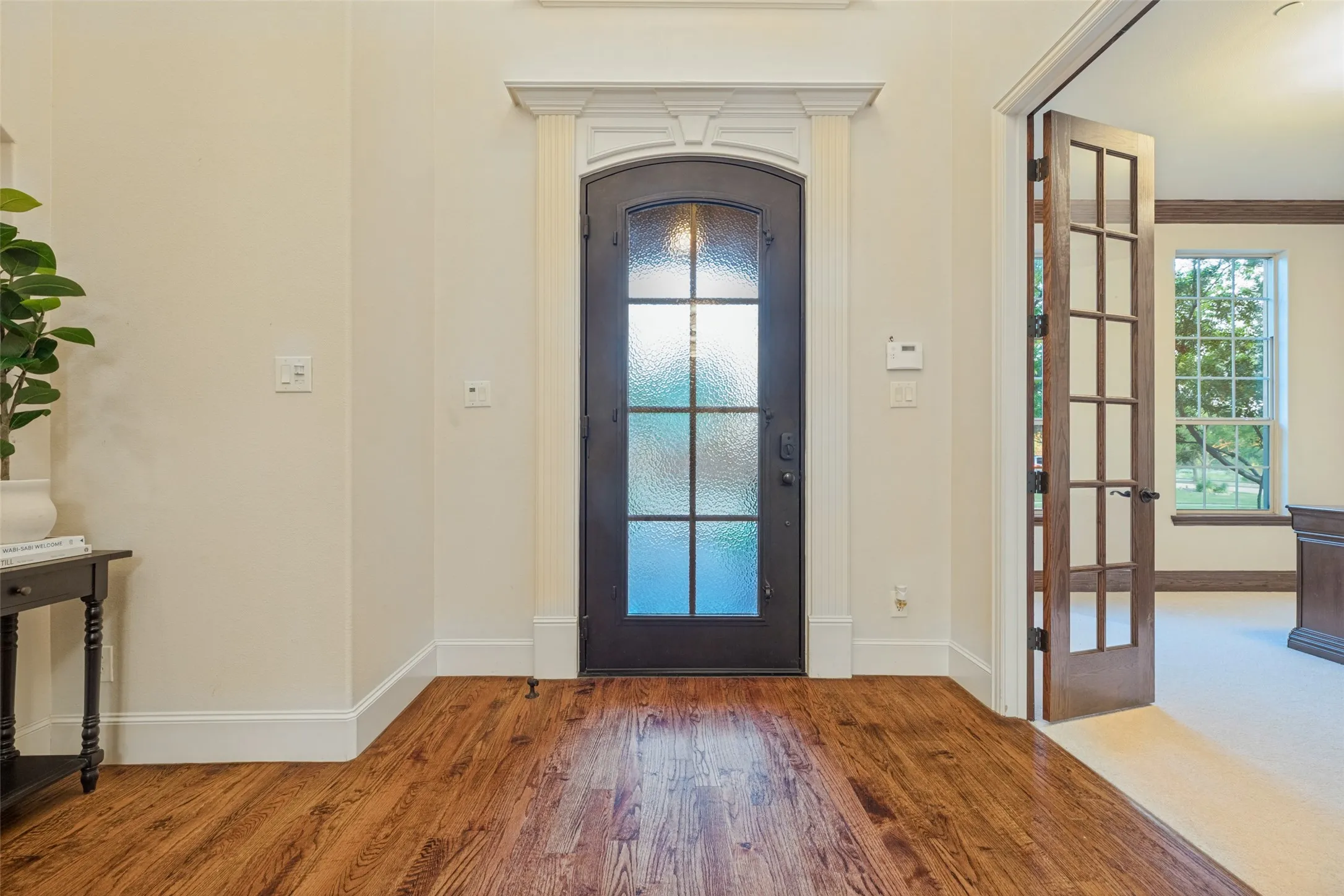 Hardwood flooring, arched doorways, wainscoting, decorative pendant lighting and chandeliers