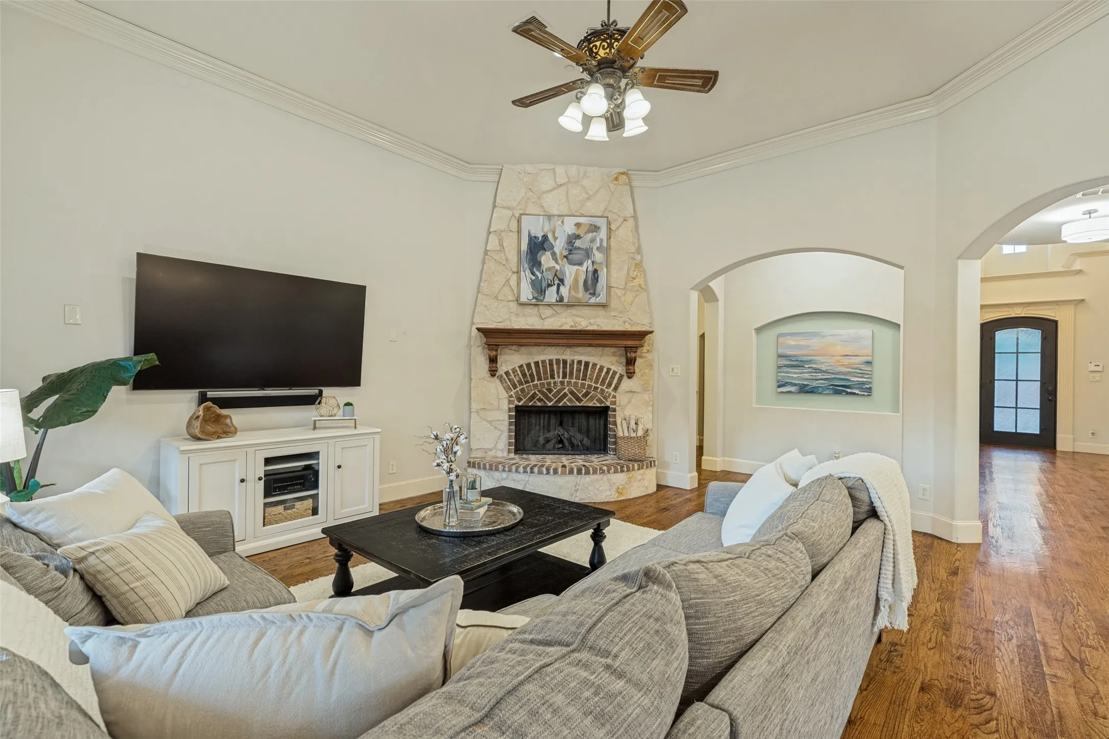Vaulted ceiling with a ceiling fan, white plantation shutters, and light-toned wall finishes
