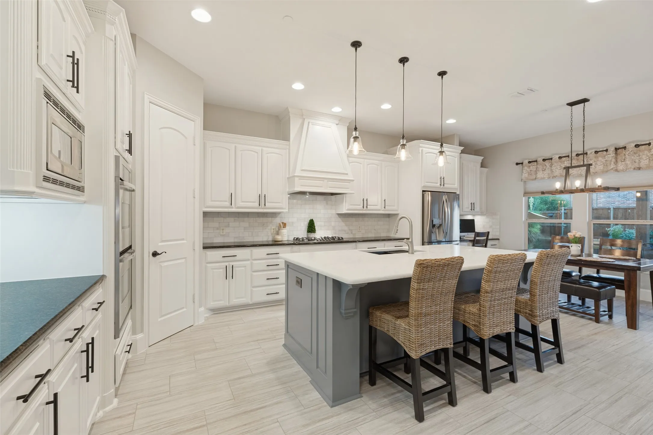 White cabinetry, stainless steel refrigerator, Quartz countertops, tile flooring, and dual dishwashers