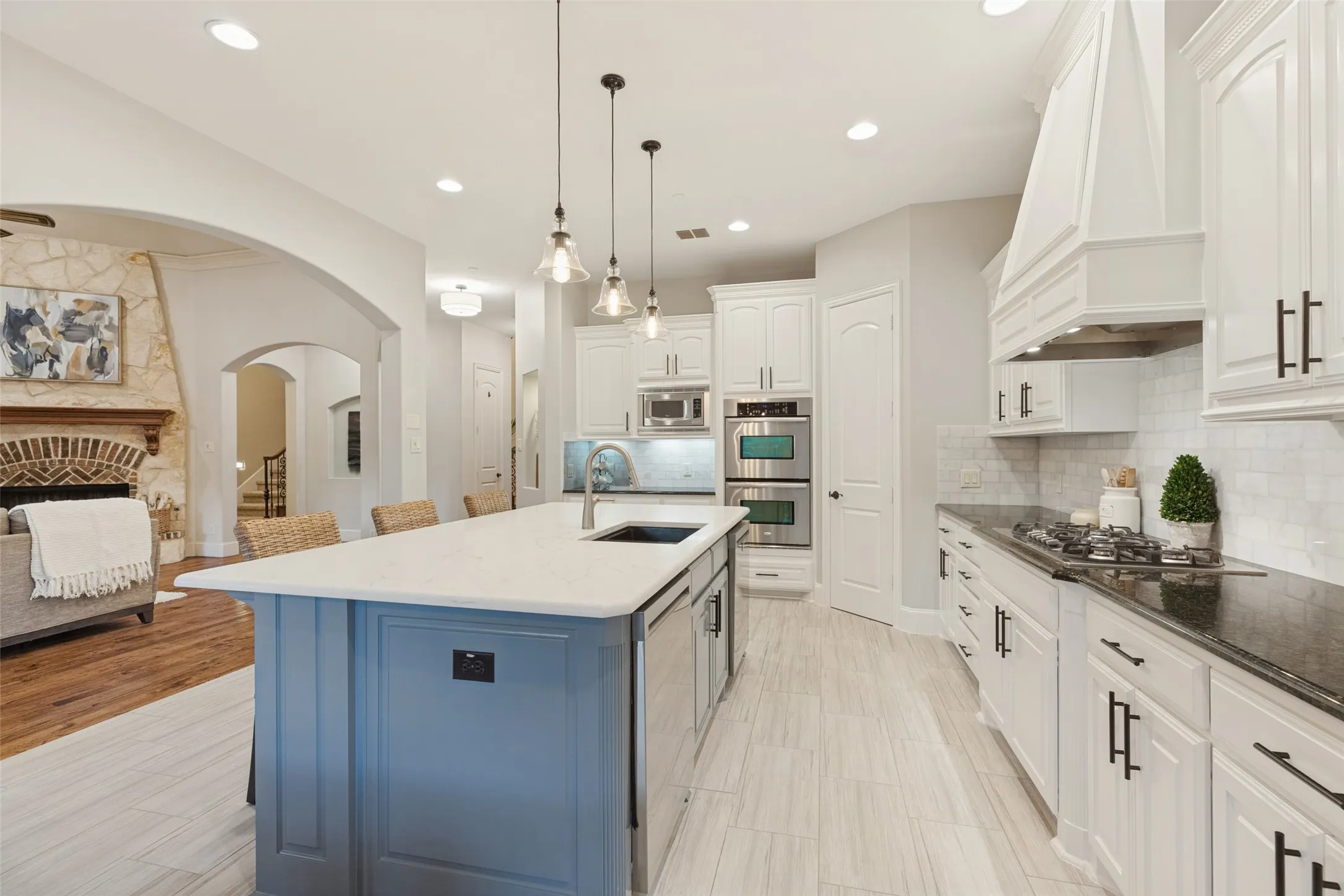 Gourmet kitchen featuring white cabinetry, stainless steel appliances, a large central island with seating
