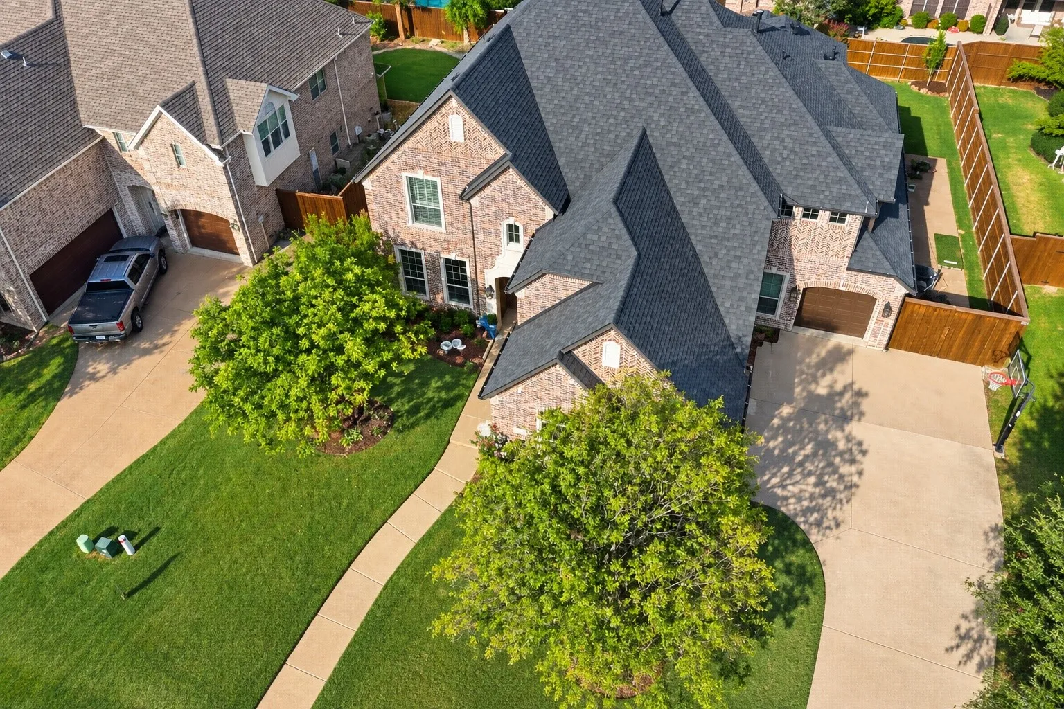 Brick exterior with multiple gables, dark shingle new roof, and attached 3 and 1 car for a total of 4 covered Garage Spaces