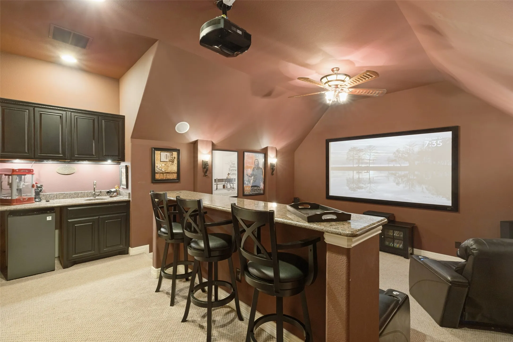 Built-in wet bar with refrigerator, dark cabinetry, granite-countertop. 5 theater seats and all media equipment included