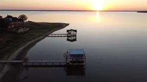 Waterfront property featuring a private boat dock with covered slip and a secondary pier