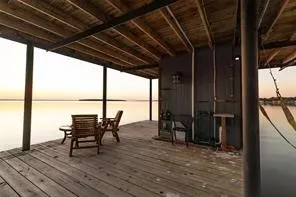 Covered pier with wood-plank decking, exposed wood ceiling, and metal wall sconce