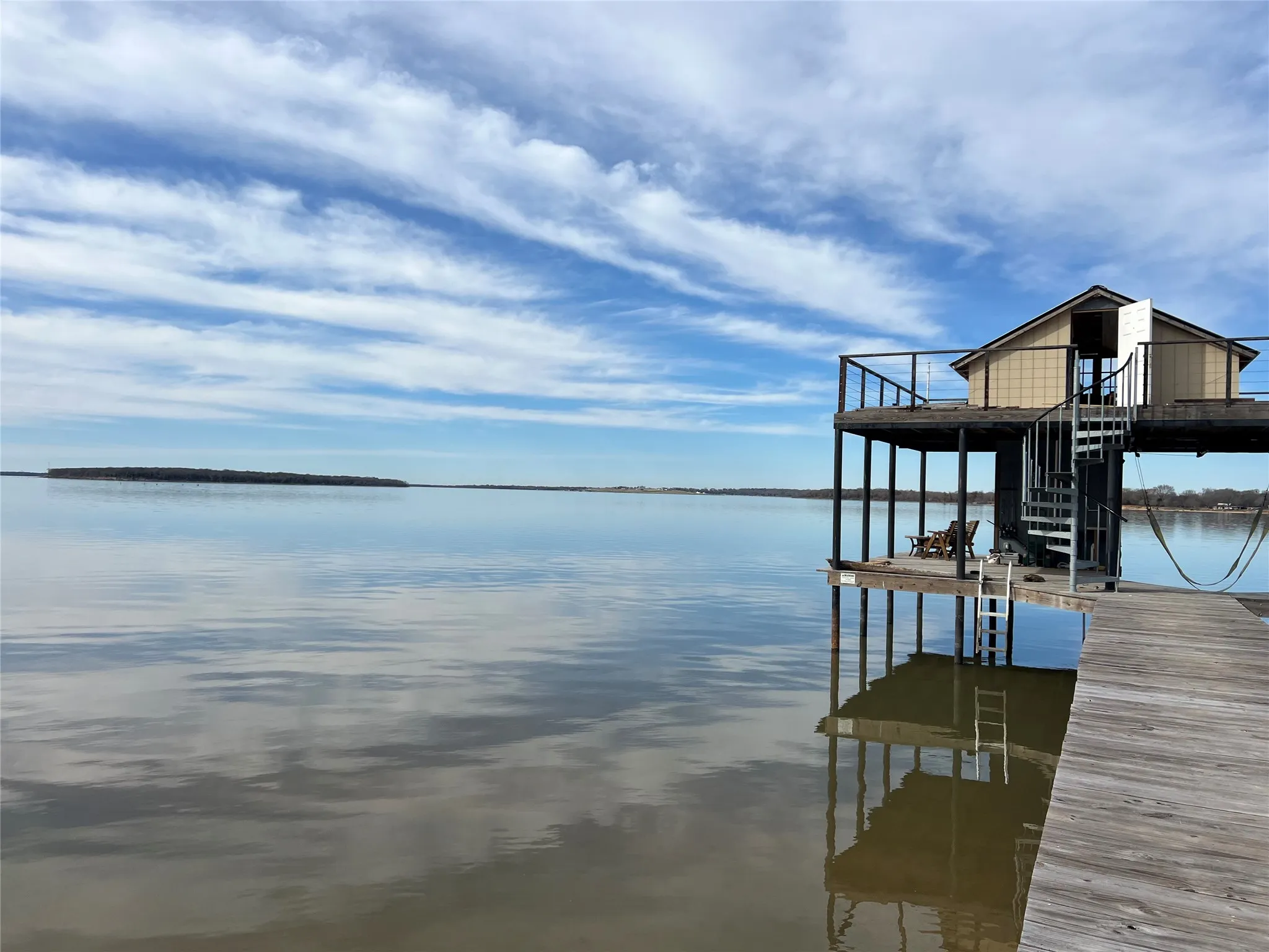 Private boat dock with elevated structure, spiral staircase, and expansive water frontage