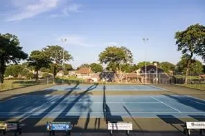 Two tennis courts with blue playing surfaces