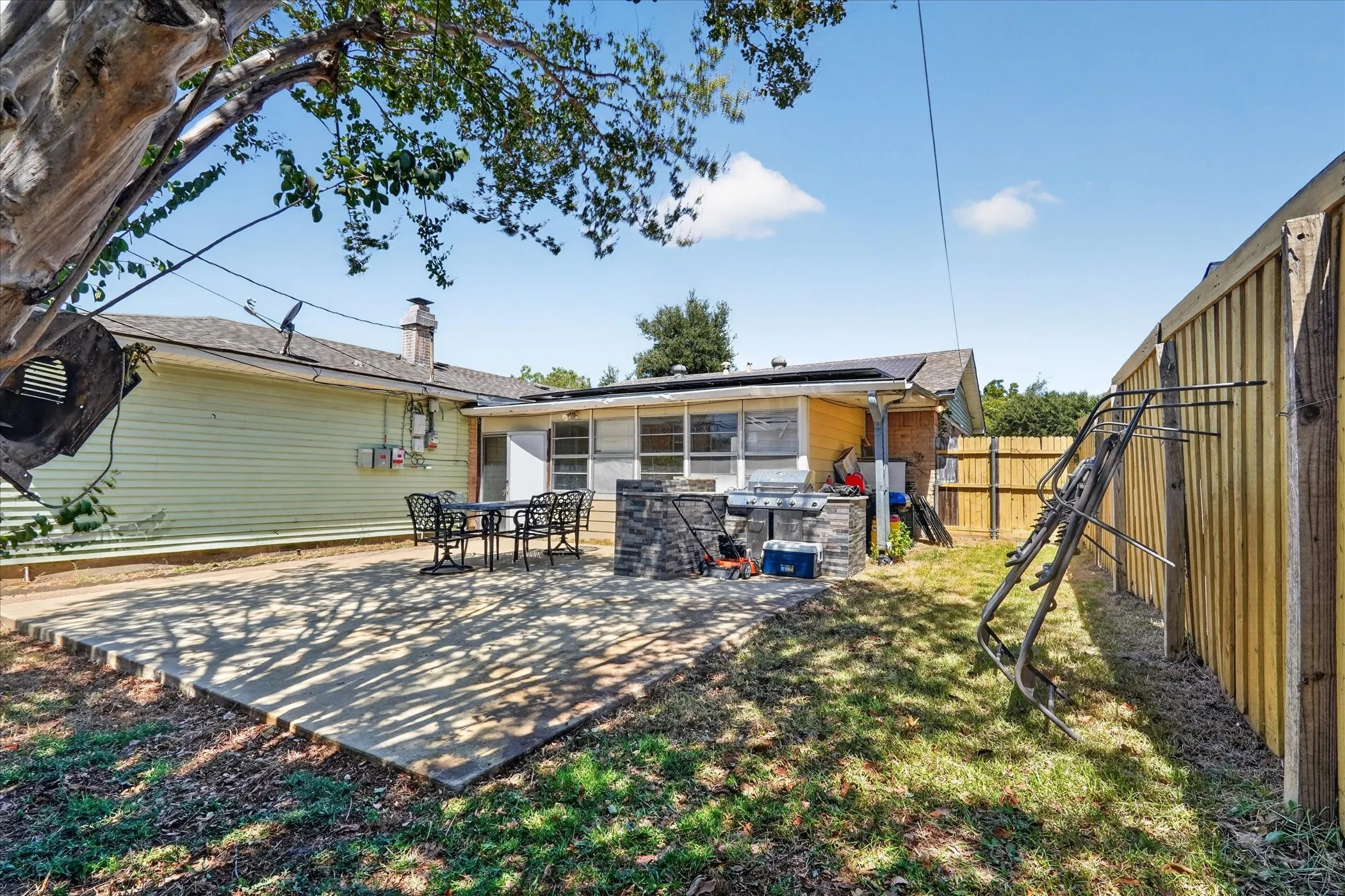 Rear exterior featuring concrete patio, horizontal siding, and partial fencing