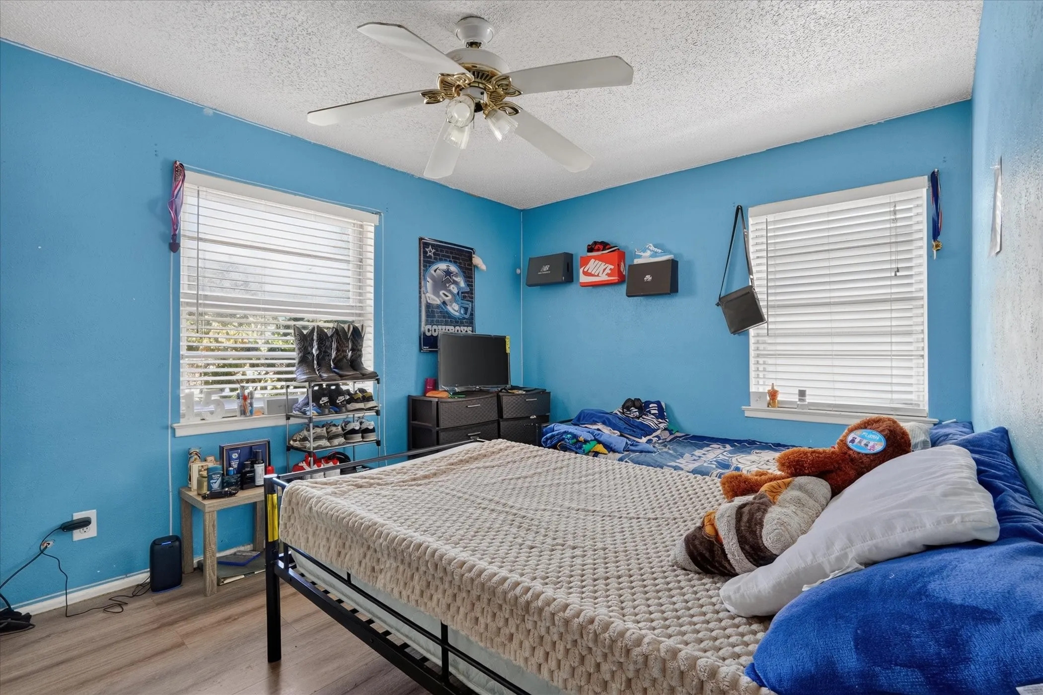 Wood-finish flooring, ceiling fan, and window with blinds
