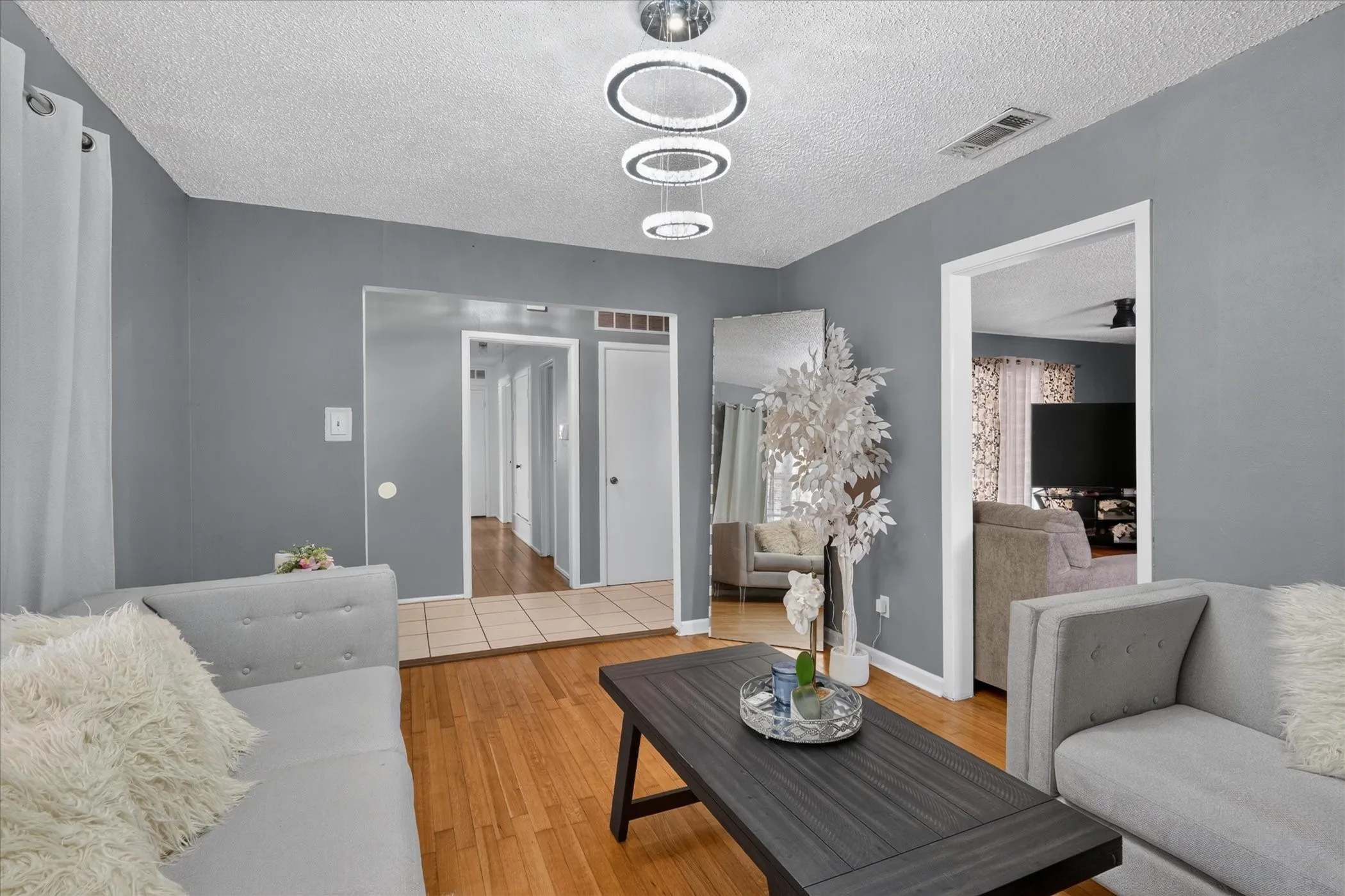 Hardwood-finish flooring, recessed lighting, modern ceiling fixture, painted walls, and white trim
