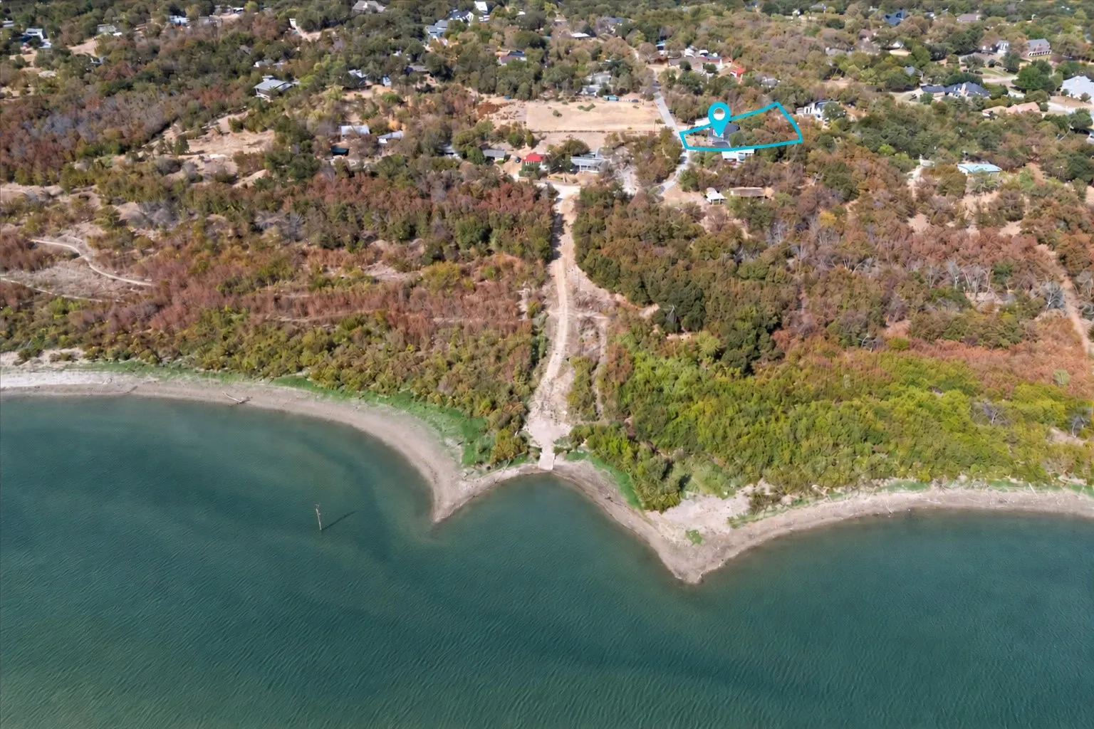 Waterfront lot featuring a natural shoreline and surrounding mature trees