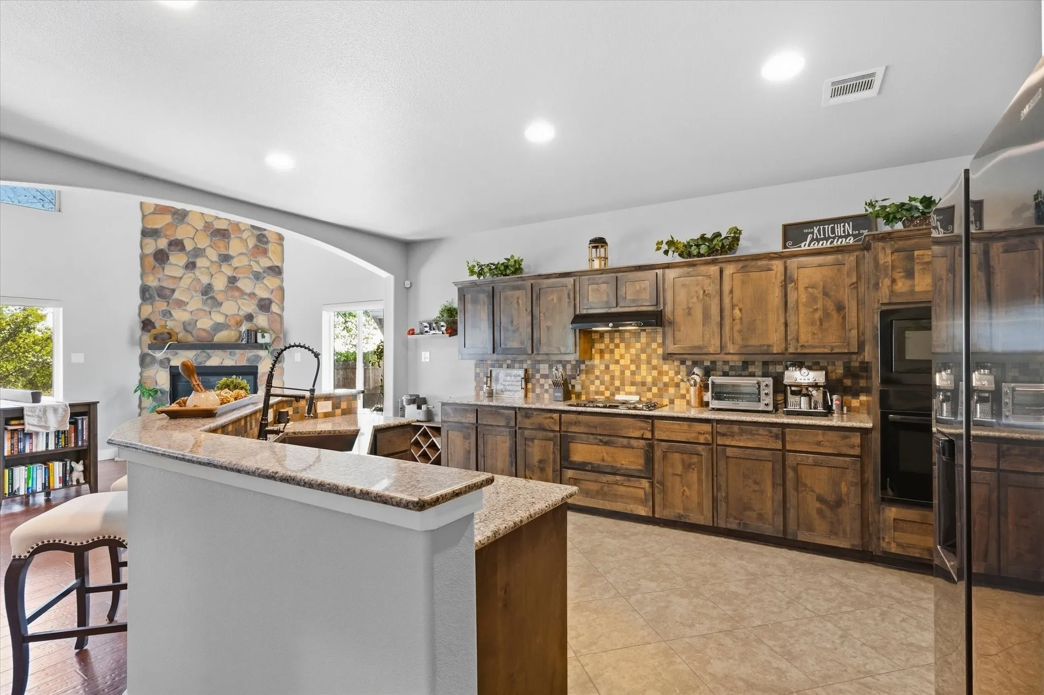 Kitchen with wood-finish cabinetry, light-toned countertops, and a mosaic tile backsplash