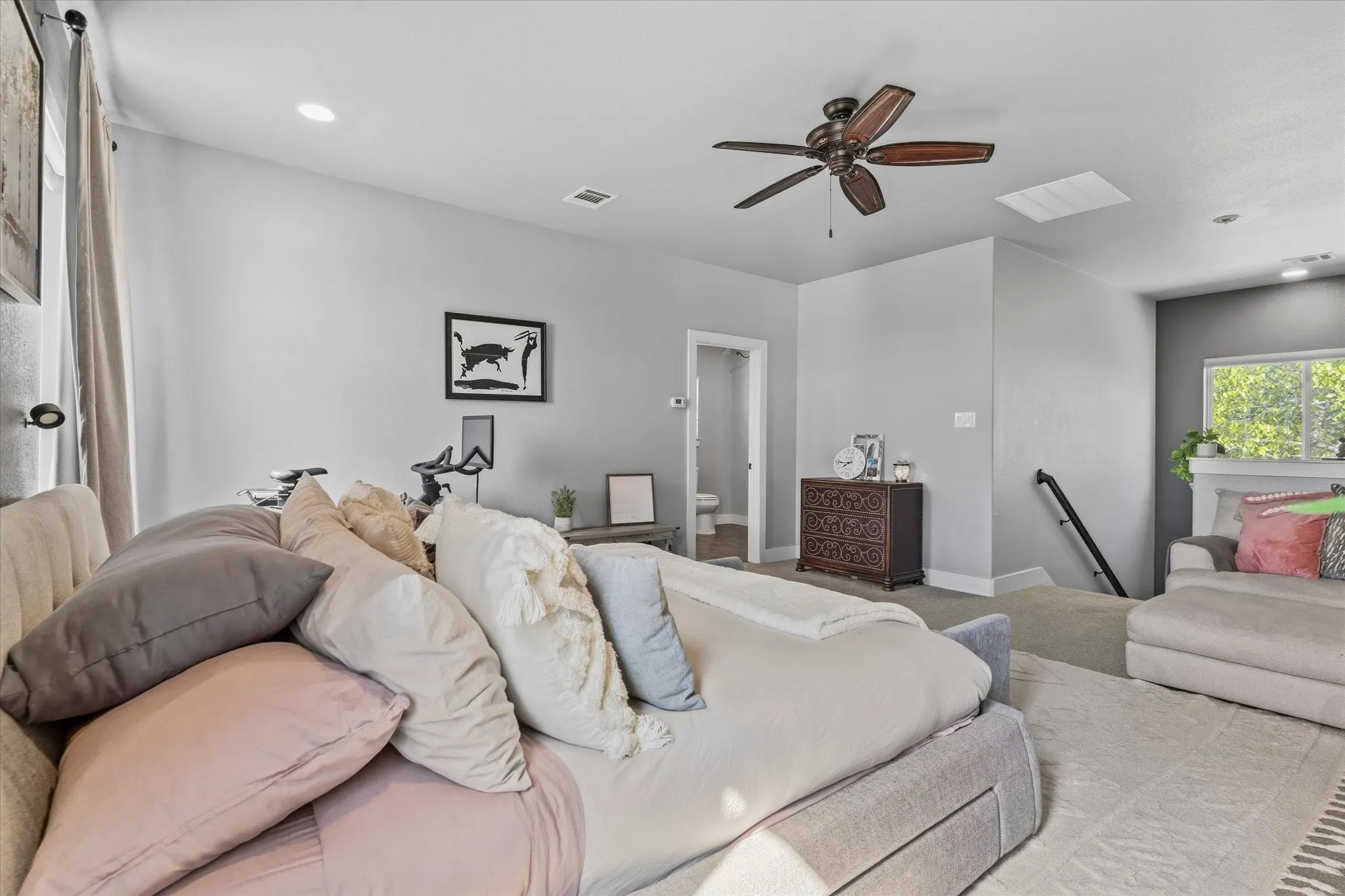 Recessed ceiling lighting, ceiling fan, natural light from exterior window, light gray wall finishes