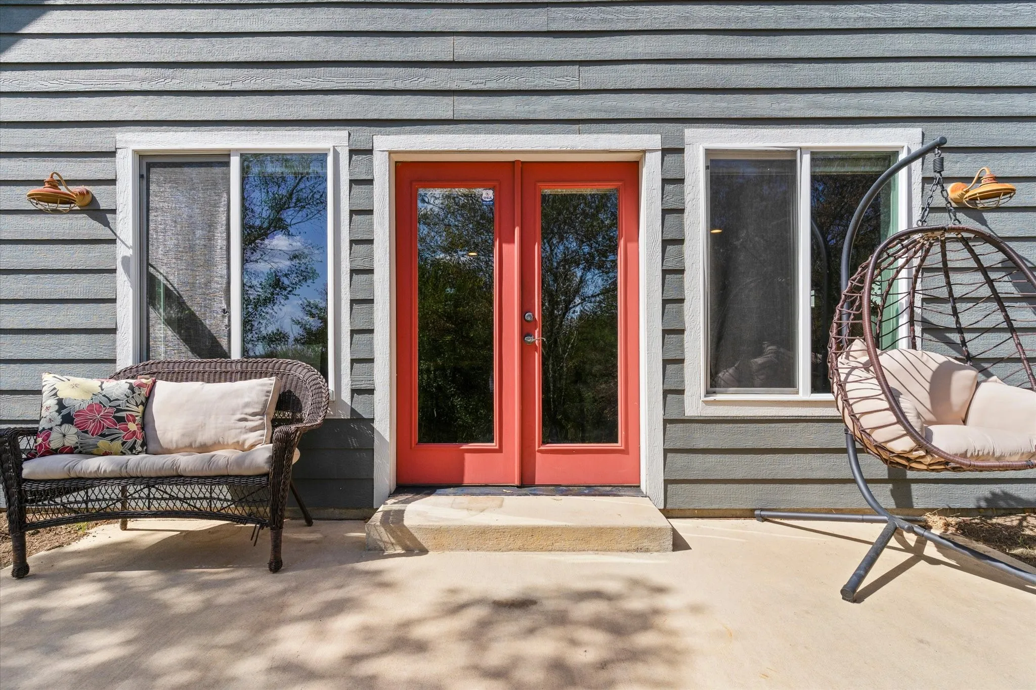 Siding exterior with a vibrant coral double-door entry and dual windows