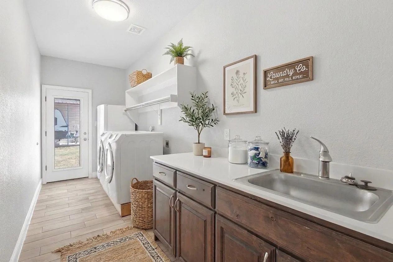 Utility room with exterior access to driveway, sink & space for extra refrigerator or freezer.