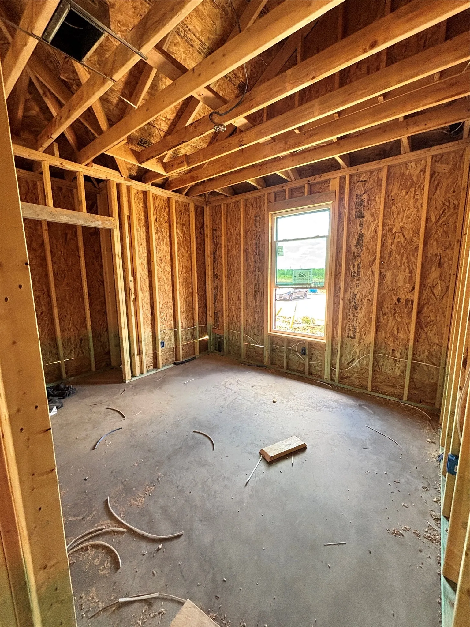 Unfinished interior framing with exposed wood studs, floor joists, and ceiling rafters