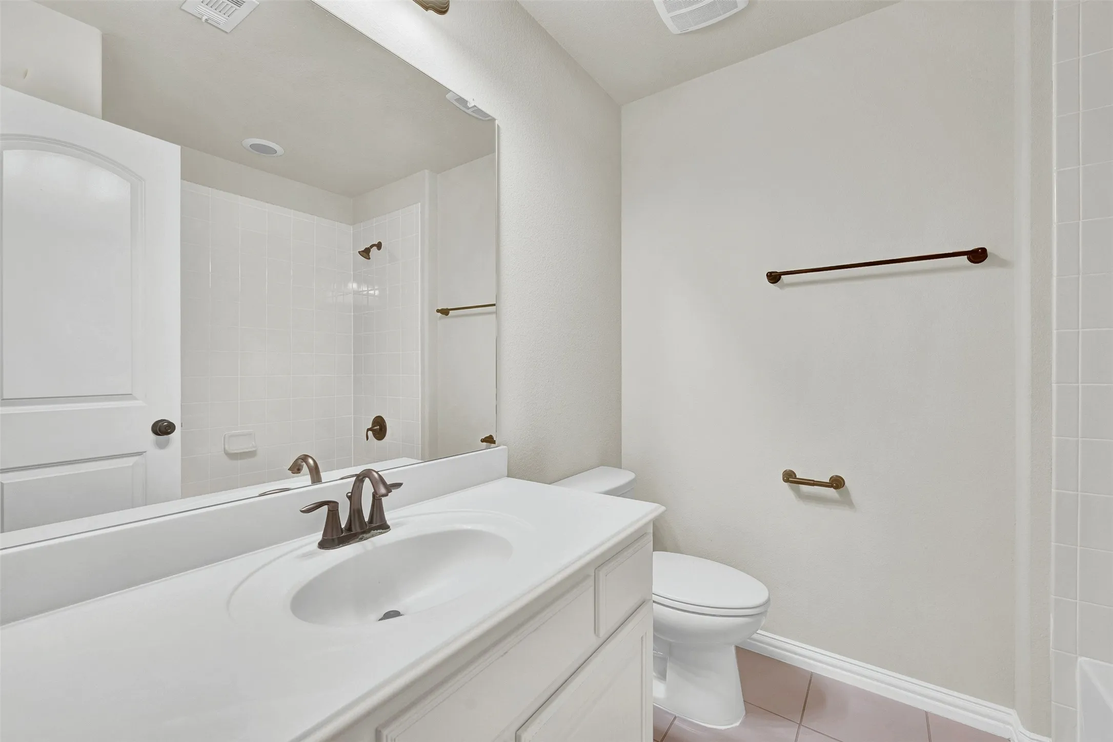 Vanity with integrated sink, bronze-finish faucet, and full-width mirror