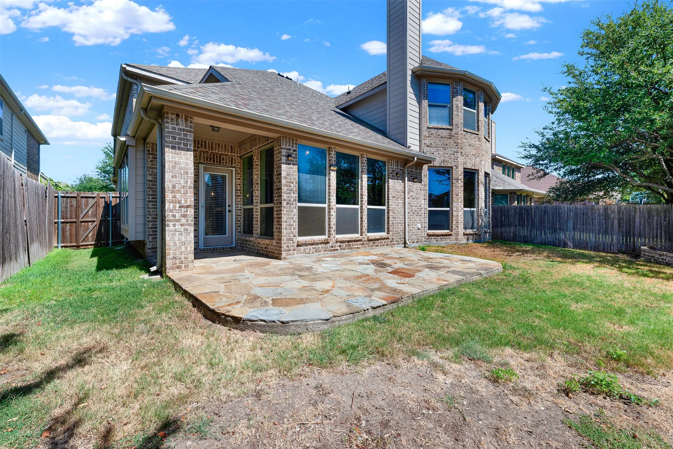 Brick exterior with a covered patio and flagstone flooring