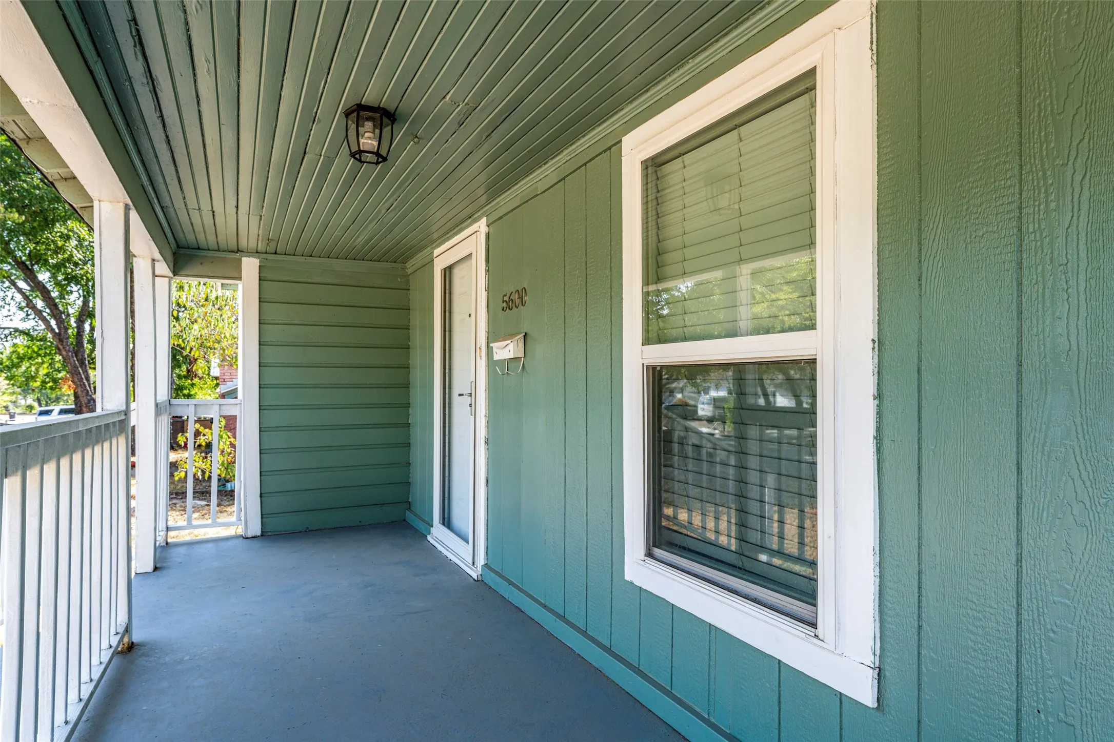 Covered porch with painted plank ceiling and dedicated lighting fixture