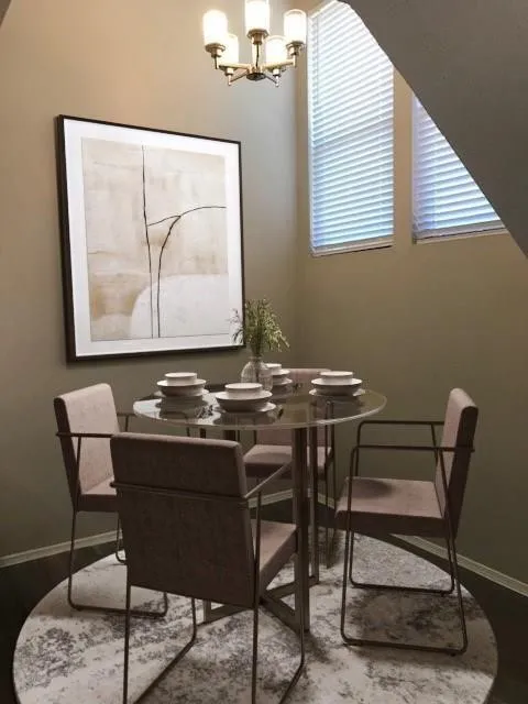 Recessed dining area featuring a modern chandelier, two large windows with blinds, and dark wood-finish flooring