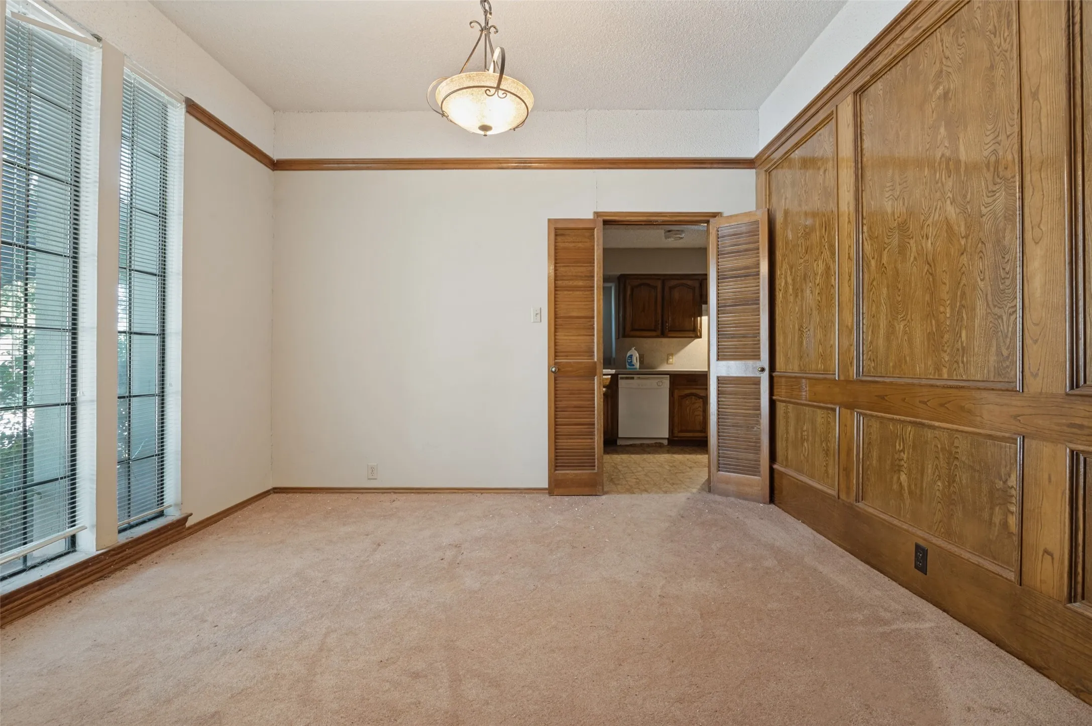 Panel wood-finish wall, dual tall windows, wood-finish trim, and a built-in ceiling light fixture