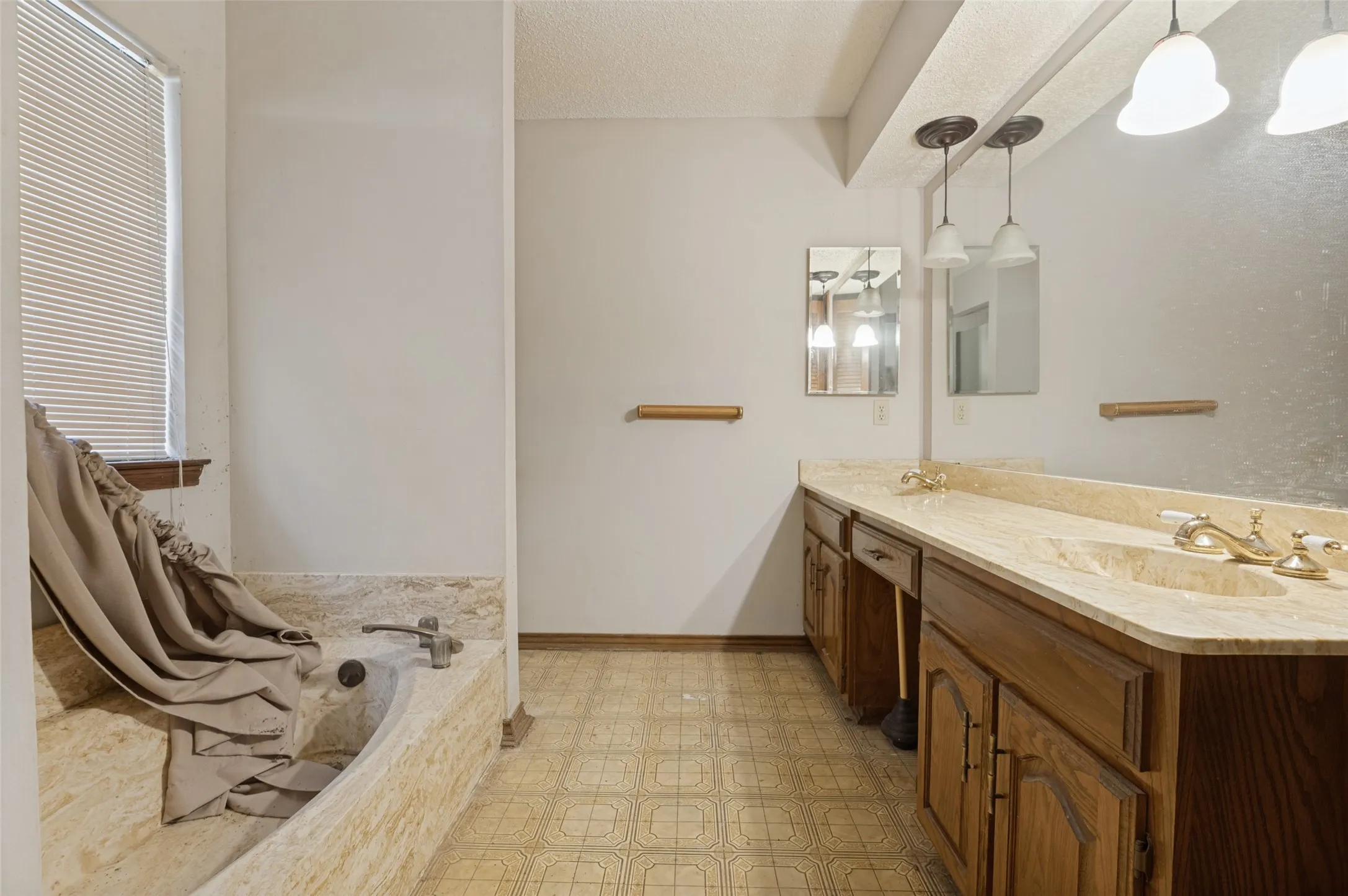 Dual vanity with integrated sinks, stone-look countertop, and wood cabinetry