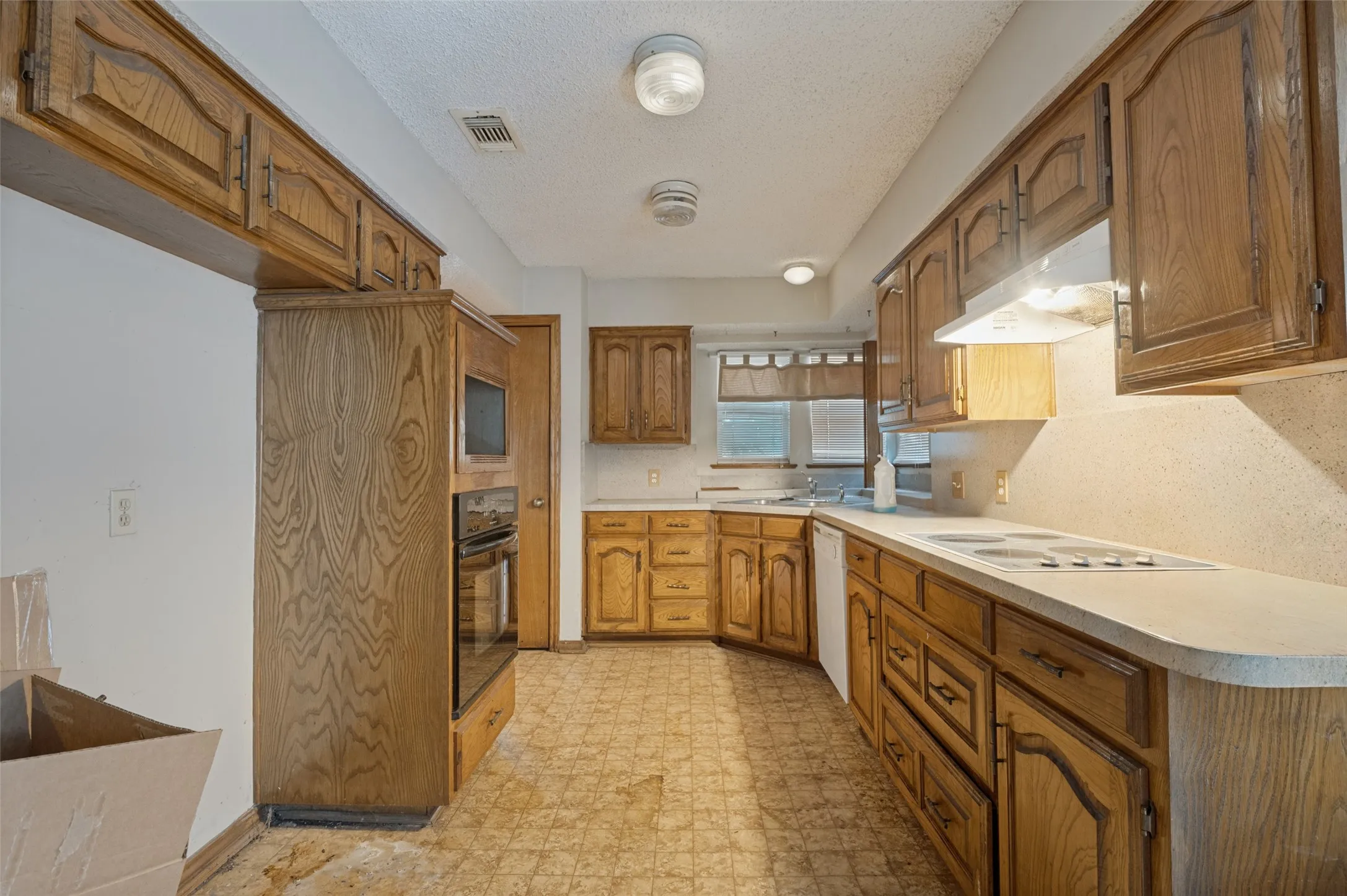 Kitchen featuring wood cabinetry, white countertops, built-in oven, and a built-in microwave