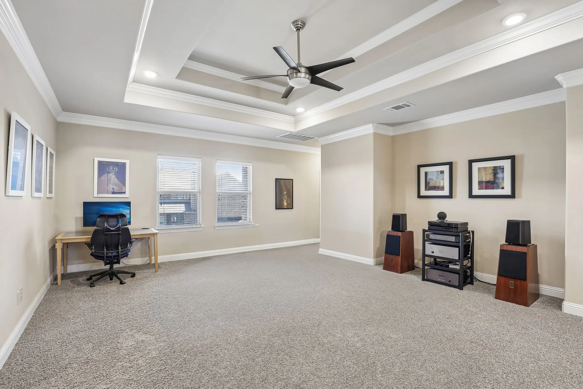 Tray ceiling with recessed lighting and a ceiling fan, crown molding, multiple windows, and neutral carpeting