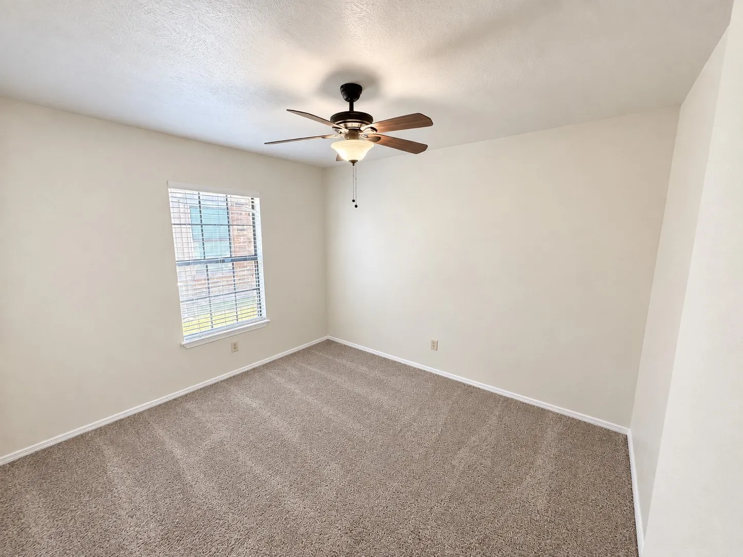 Neutral-toned walls complement plush carpeting