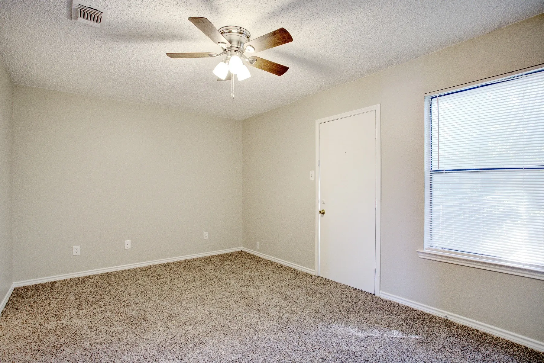 Neutral-toned walls complement the textured carpeting