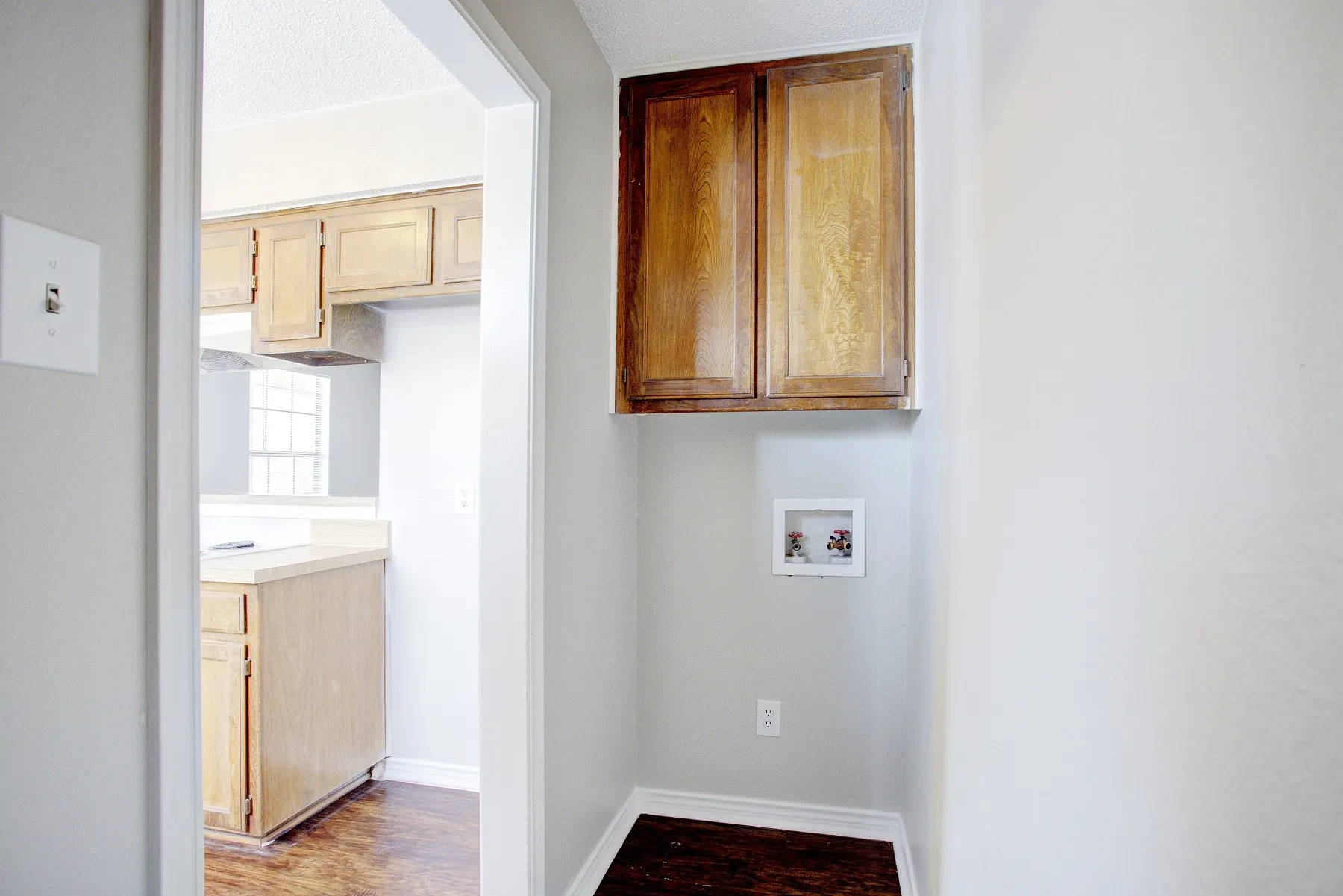 Dedicated laundry area with upper wood-finish cabinetry