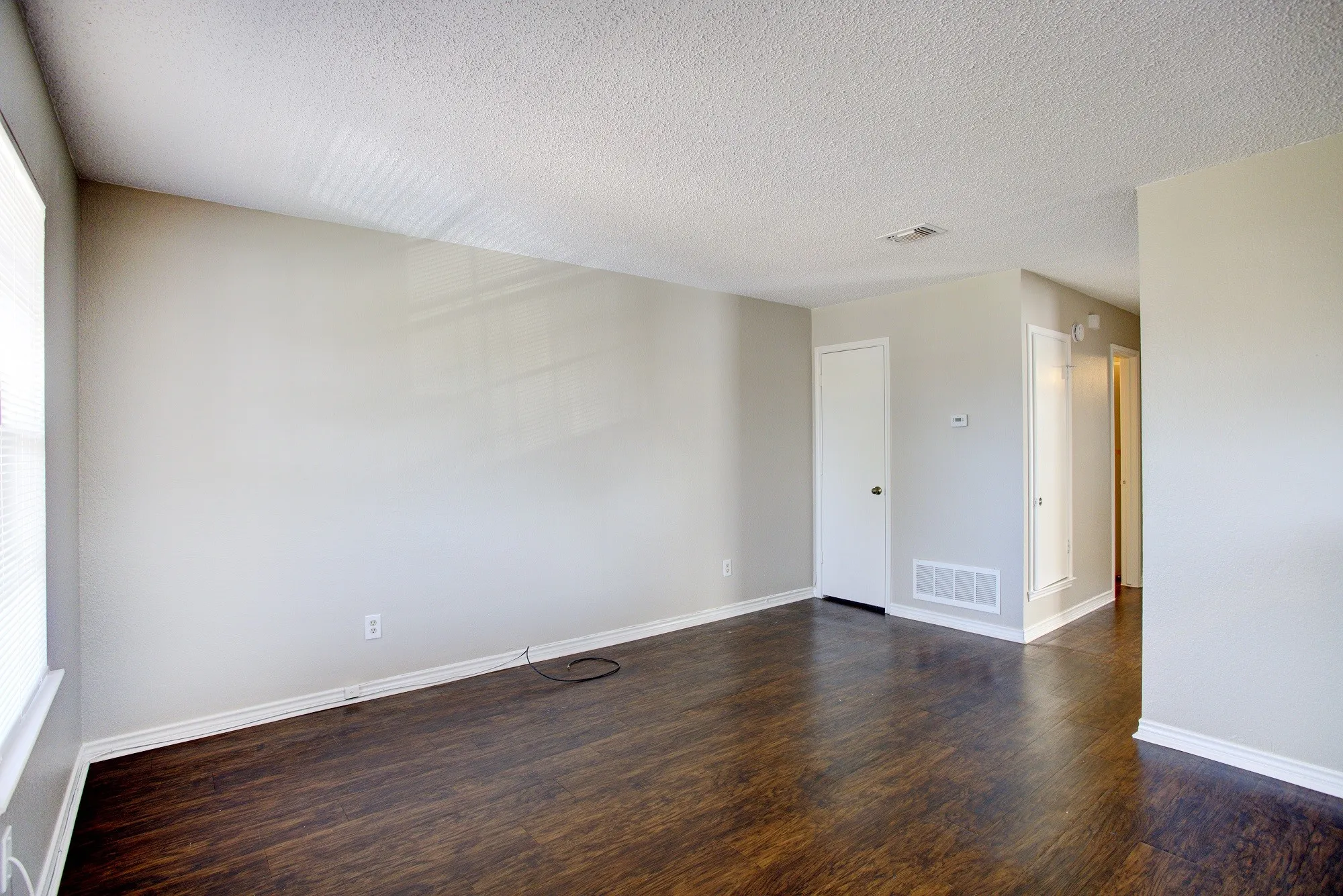 Wood-finish flooring throughout, light-toned wall paint, and white trim