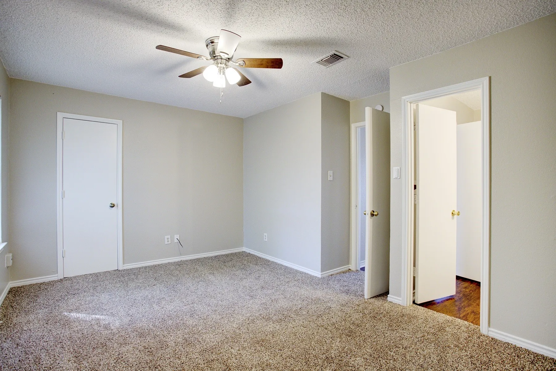 Neutral-toned walls complement the textured carpet flooring