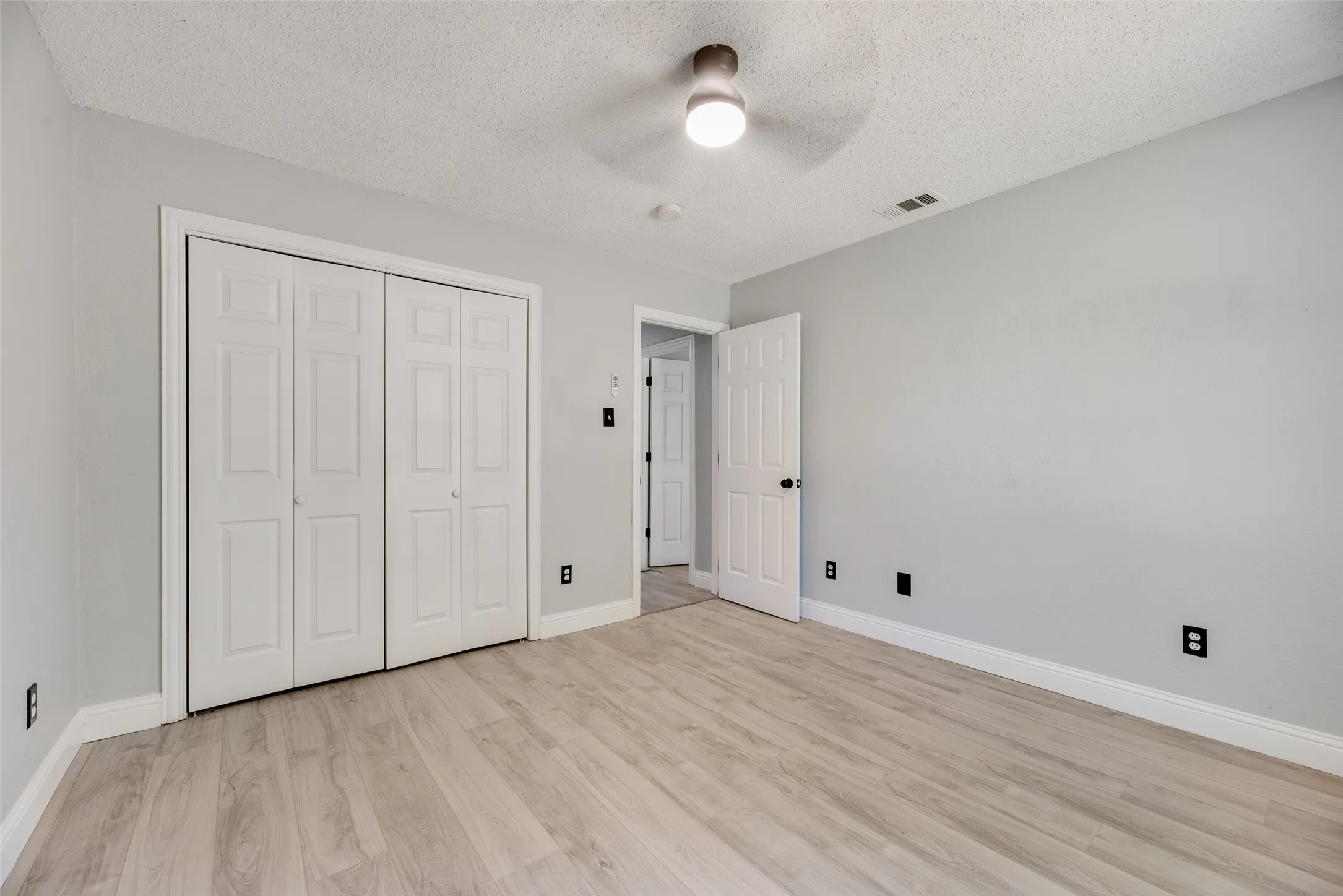 Light wood-finish flooring with white trim