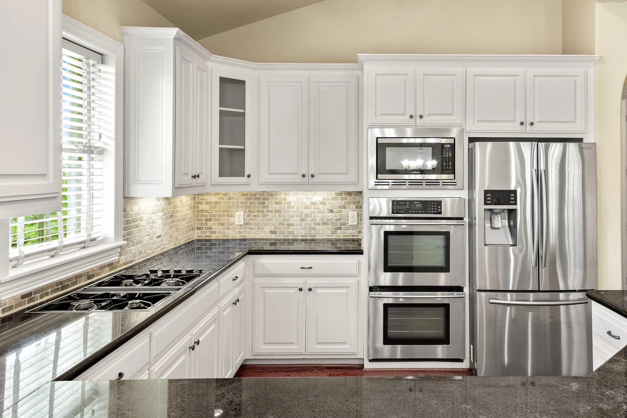Kitchen area, including stainless steel appliances, refrigerator, double oven, microwave, wine refrigerator, and dishwasher