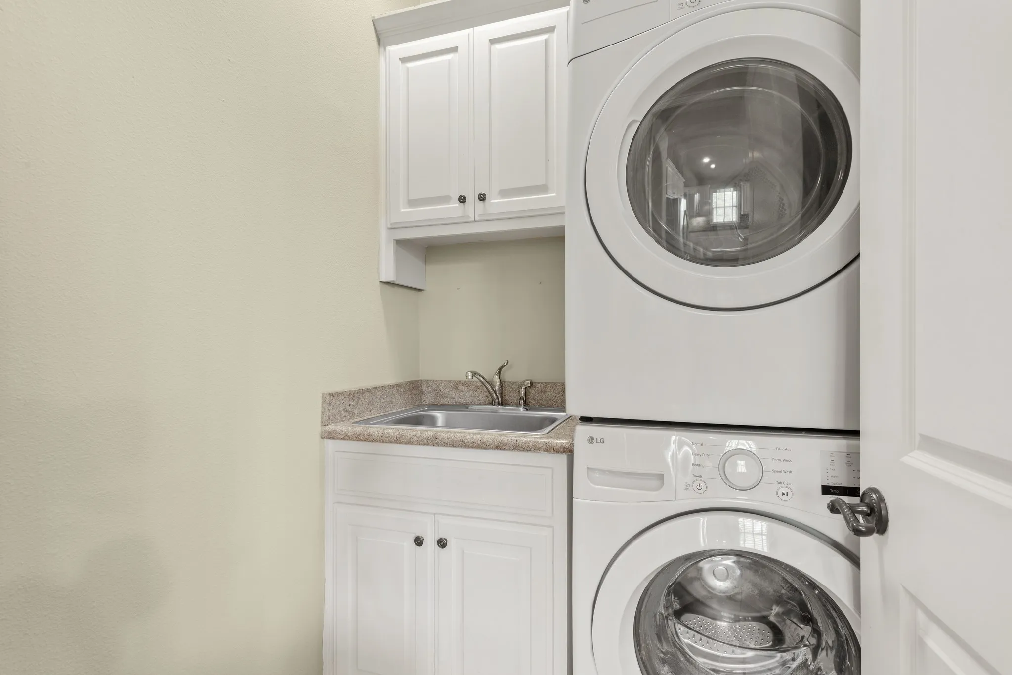 Laundry room including stacked washer and dryer