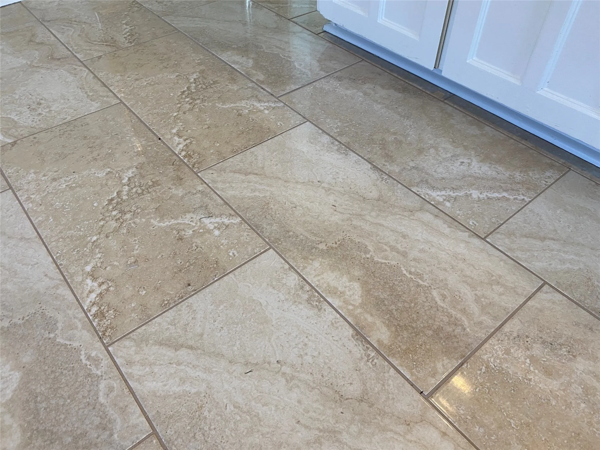 Neutral-toned rectangular tile flooring paired with white cabinetry