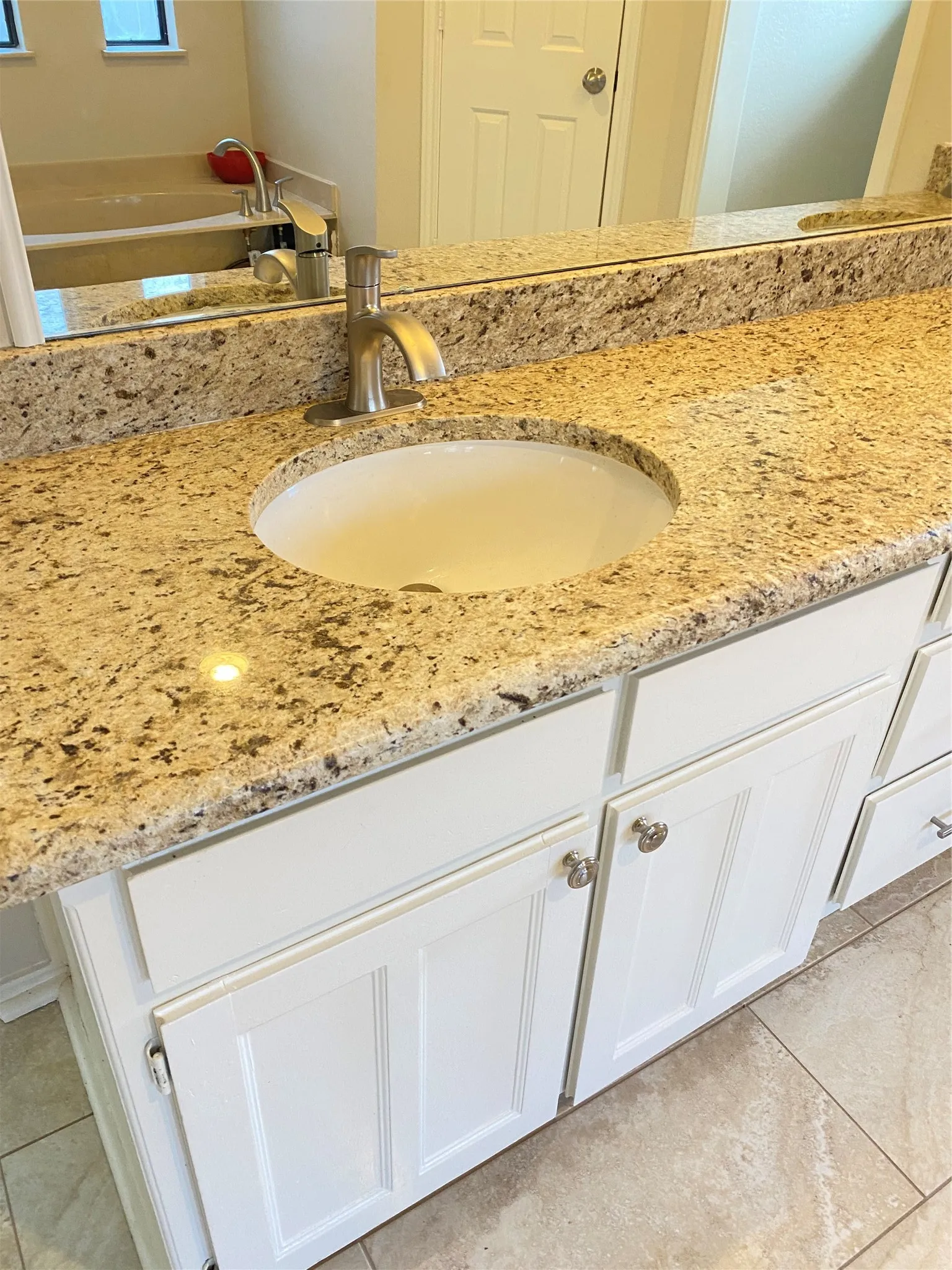 Undermount sink with a brushed nickel faucet, set into a speckled countertop