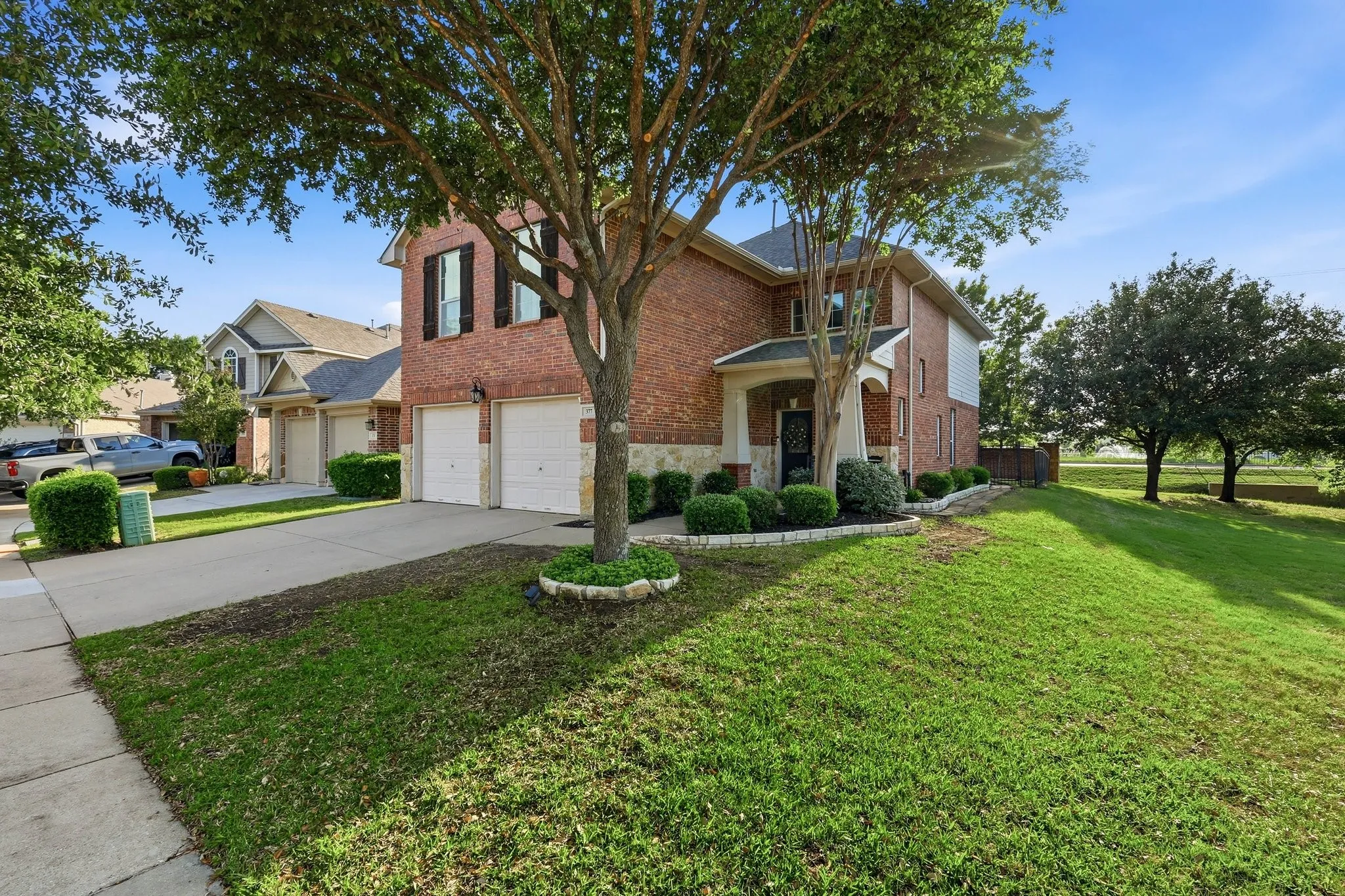 Brick exterior with stone accents, covered entry, and attached multi-car garage