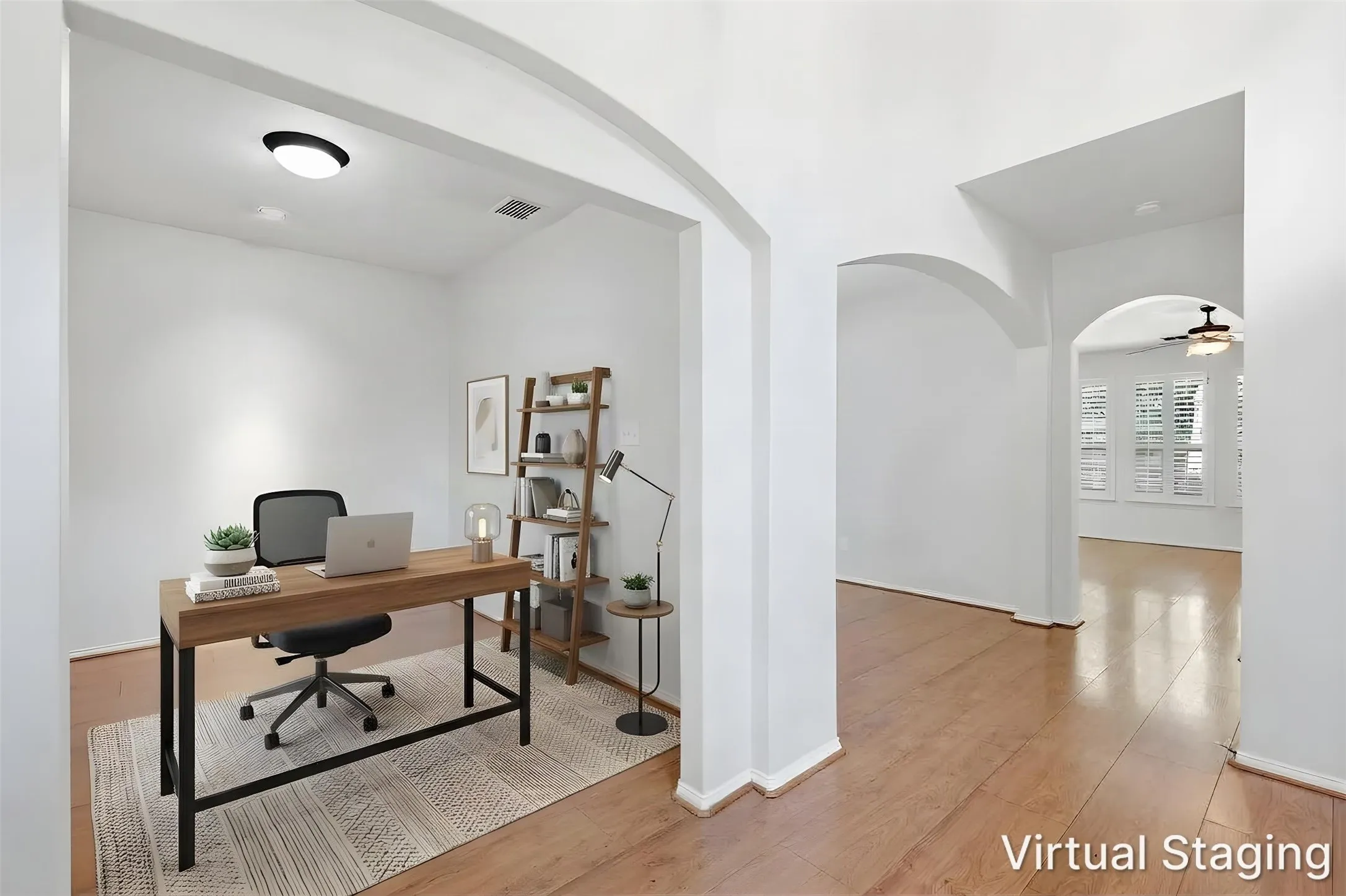 Arched doorways define the entry to an office space with ceiling mounted lighting and wood-finish flooring