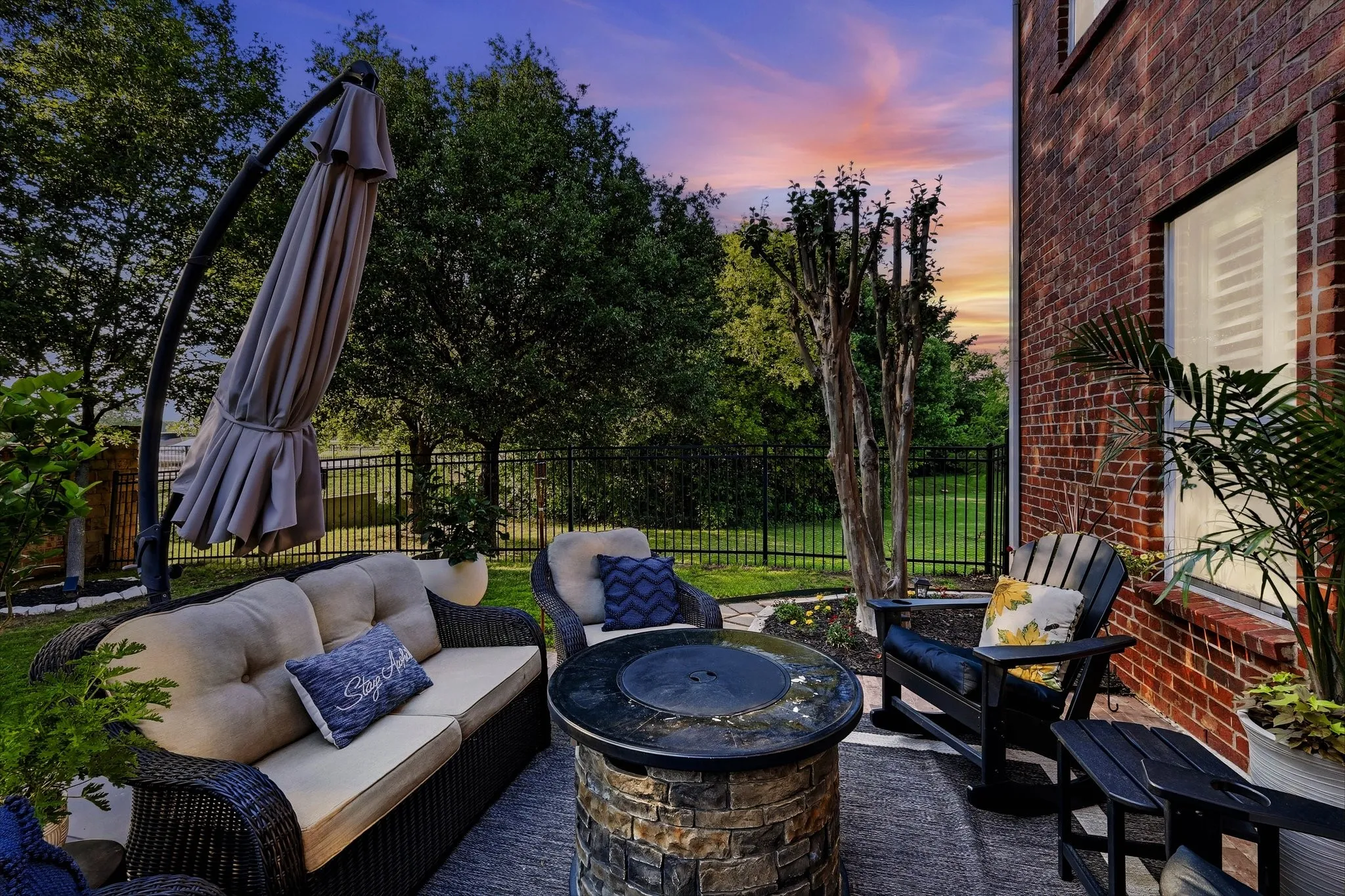 Paved patio area featuring a stone-clad fire pit