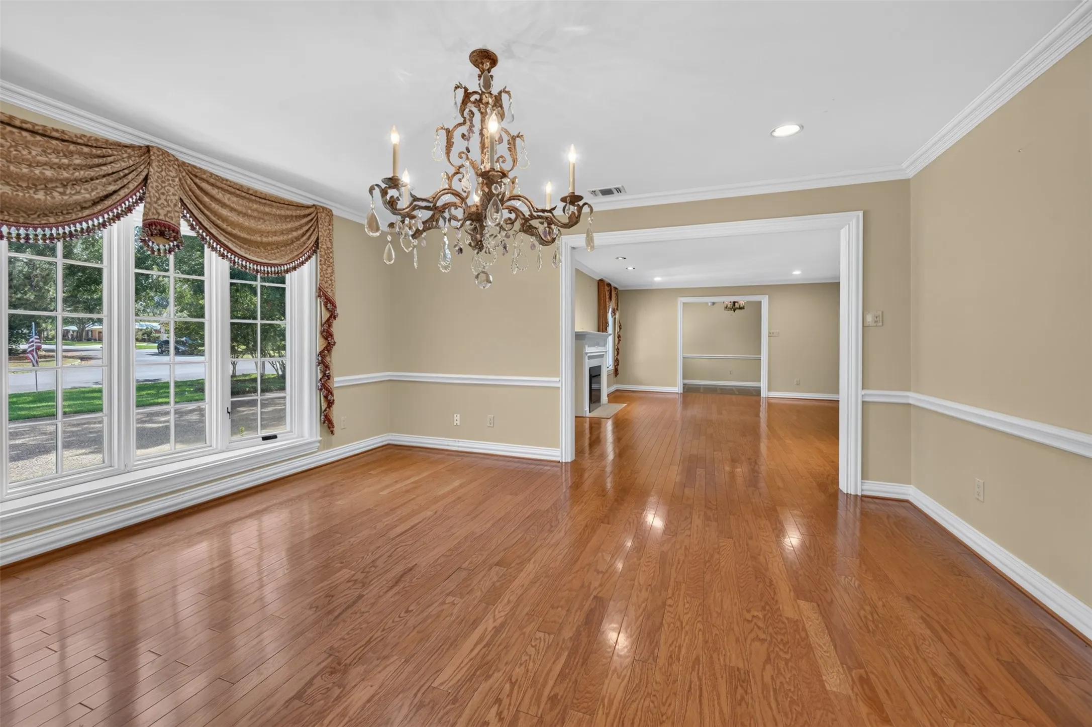 Hardwood flooring, decorative chandelier, crown molding, wall trim, recessed lighting