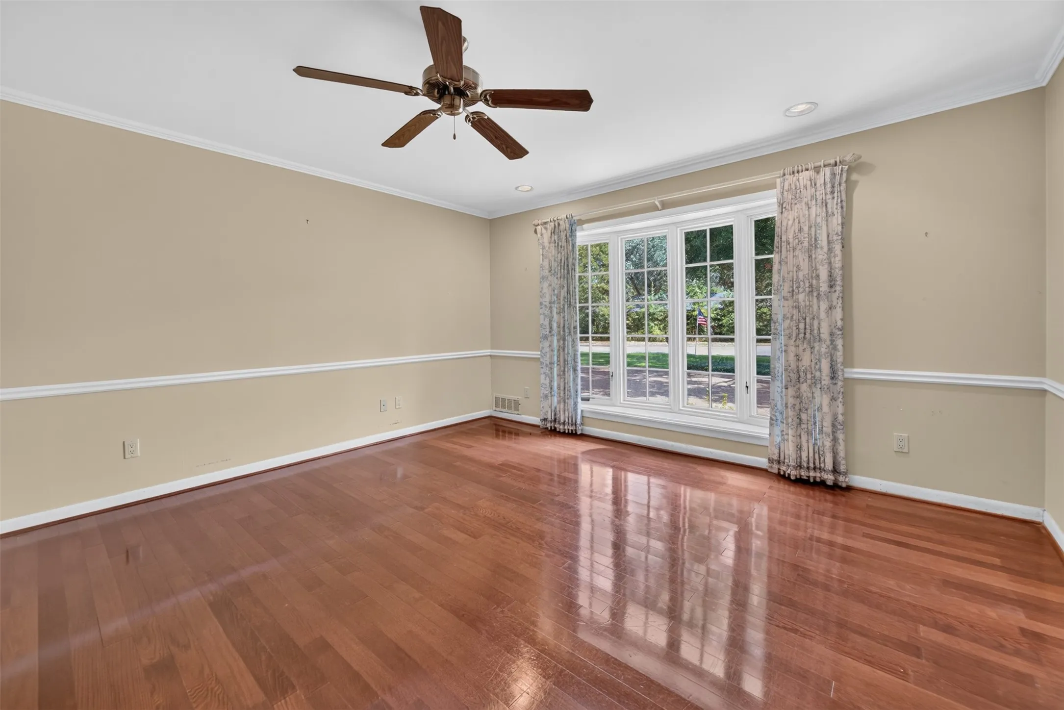 Hardwood flooring, crown molding, chair rail molding, recessed lighting, and a ceiling fan