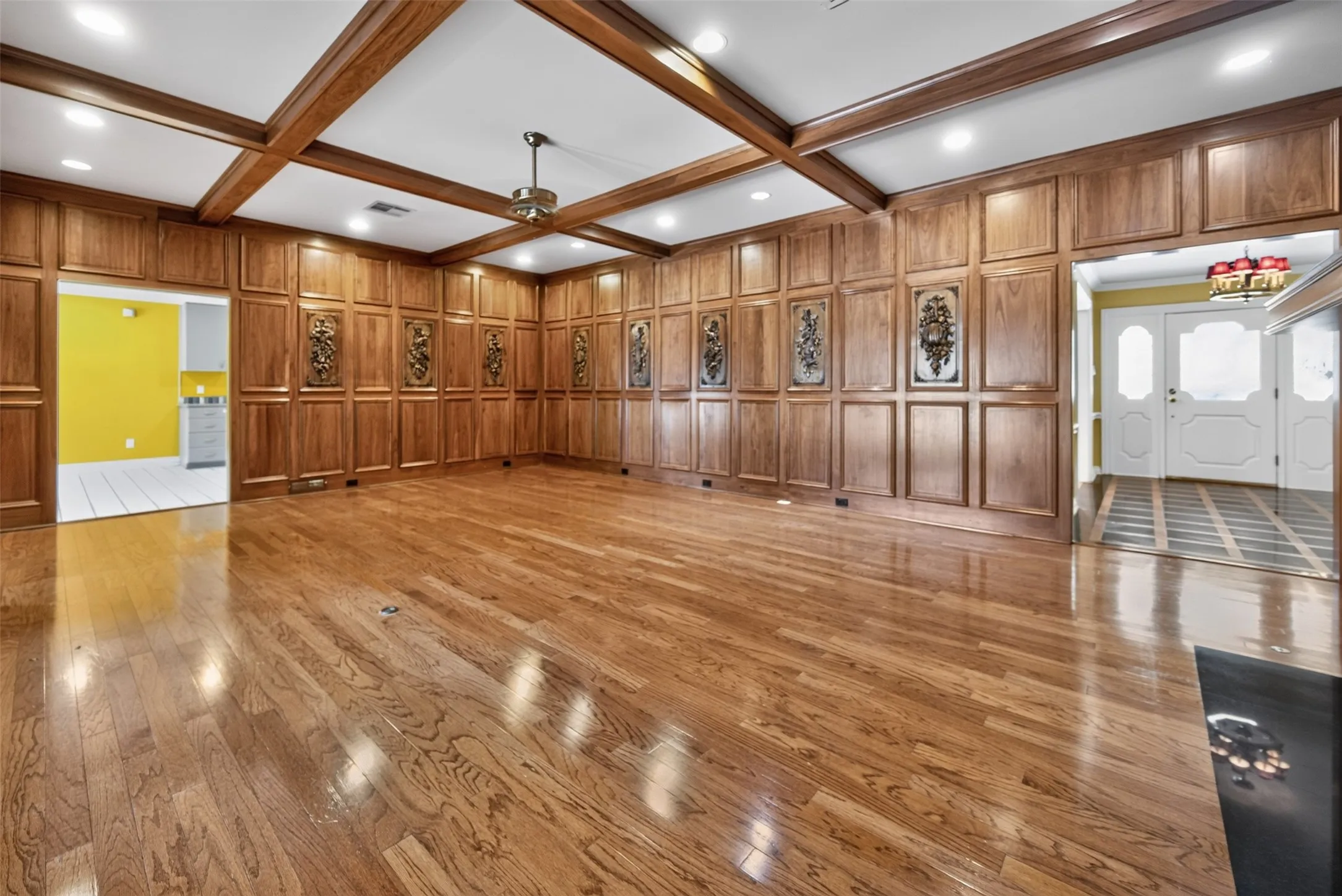 Hardwood flooring, wood paneling, wood-beamed ceiling, recessed lighting, and a ceiling fan
