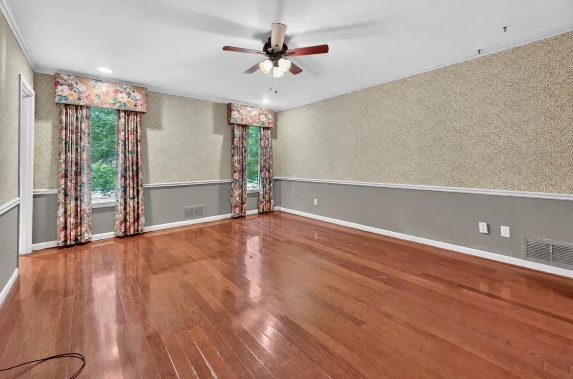 Hardwood flooring, crown molding, chair rail, and ceiling fan with light fixture