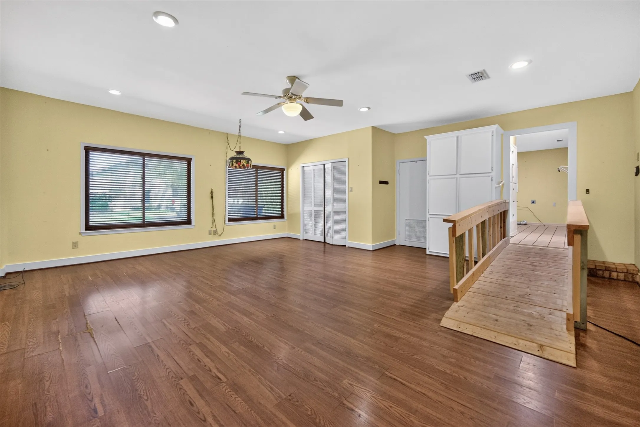 Spacious room with wood-finish flooring, recessed lighting, and a ceiling fan