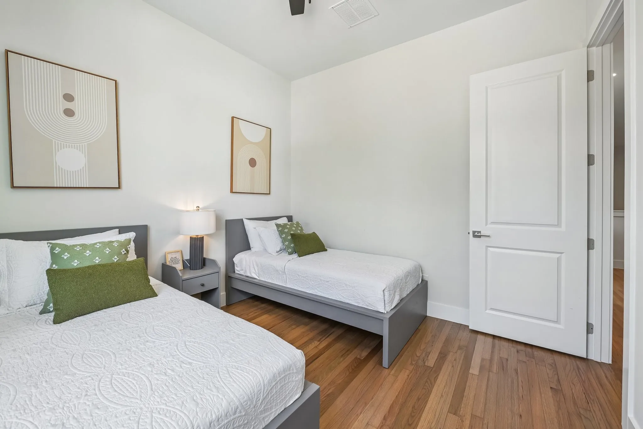 Hardwood-style flooring, white paneled door, and recessed ceiling vent