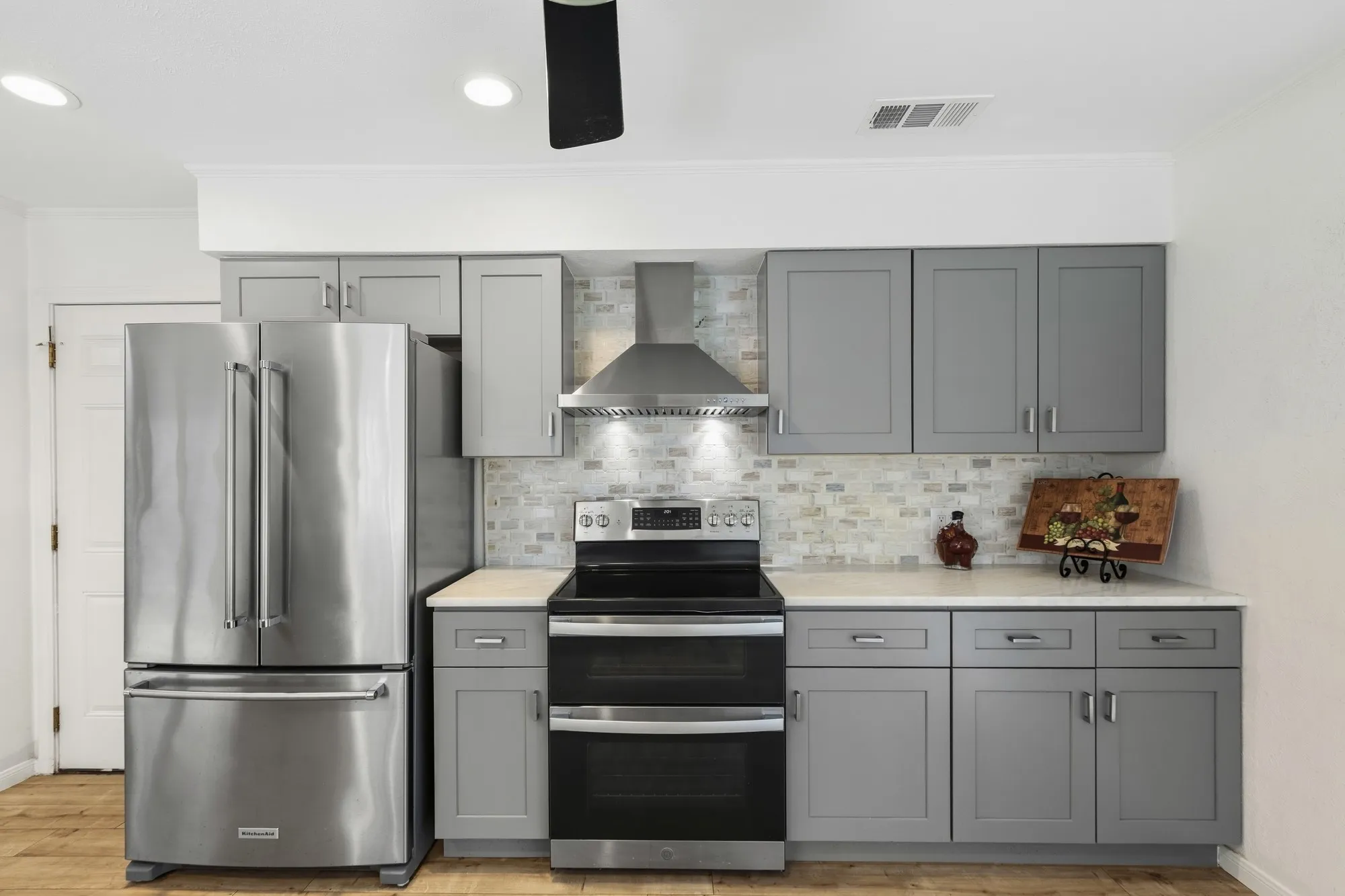 Stainless appliances with double convection oven stand out against gorgeous stone backsplash