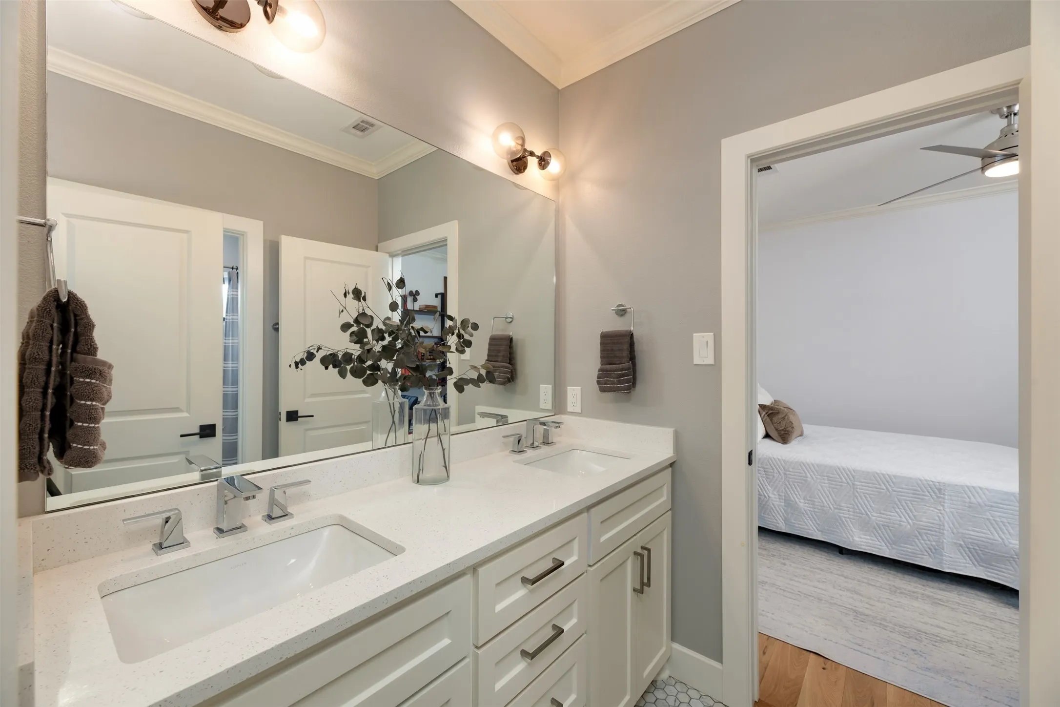 Dual vanity with integrated sinks, chrome-finish fixtures, and a large wall-mounted mirror