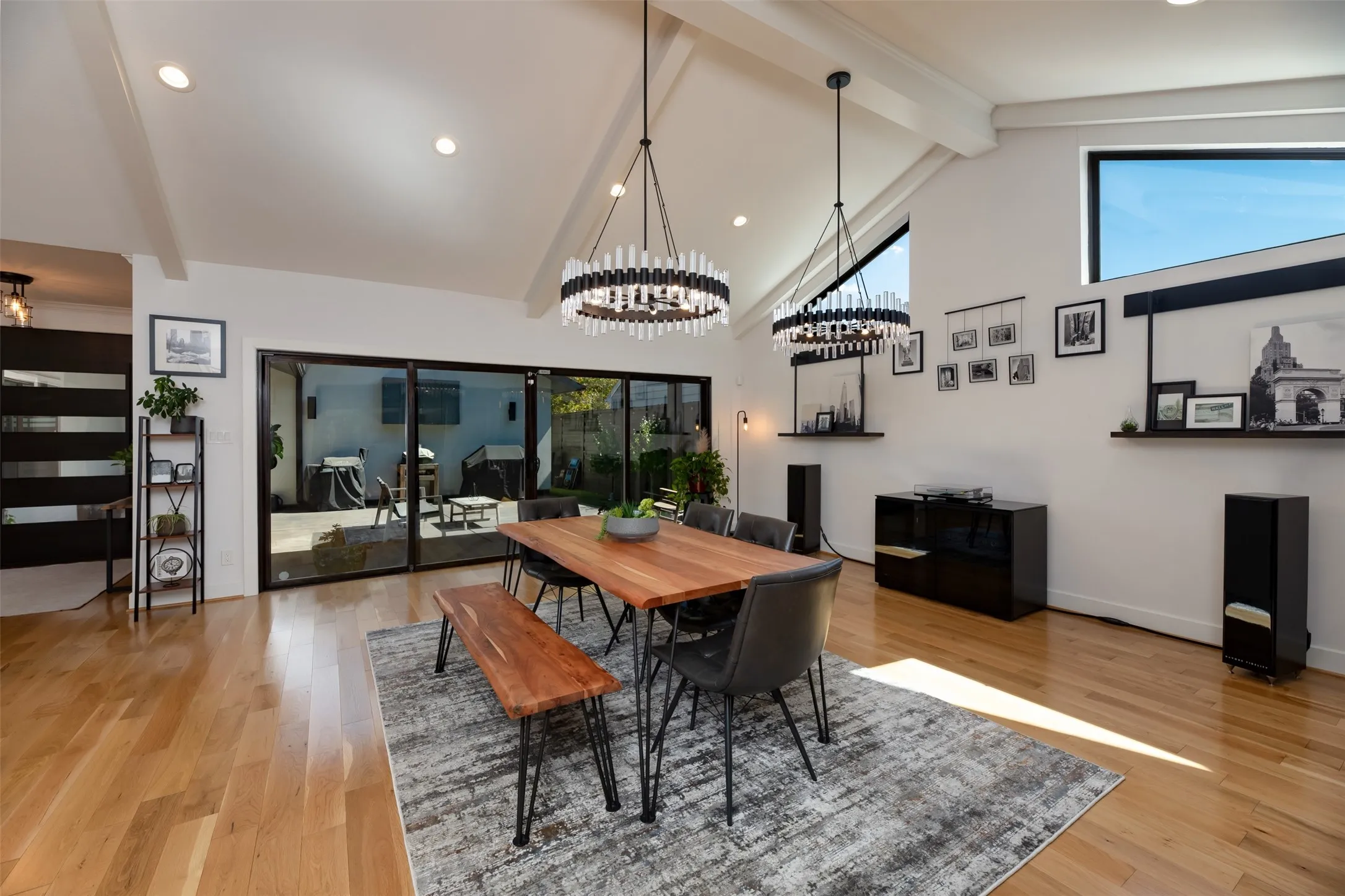 Vaulted ceilings with exposed beams, recessed lighting, and wood-finish flooring